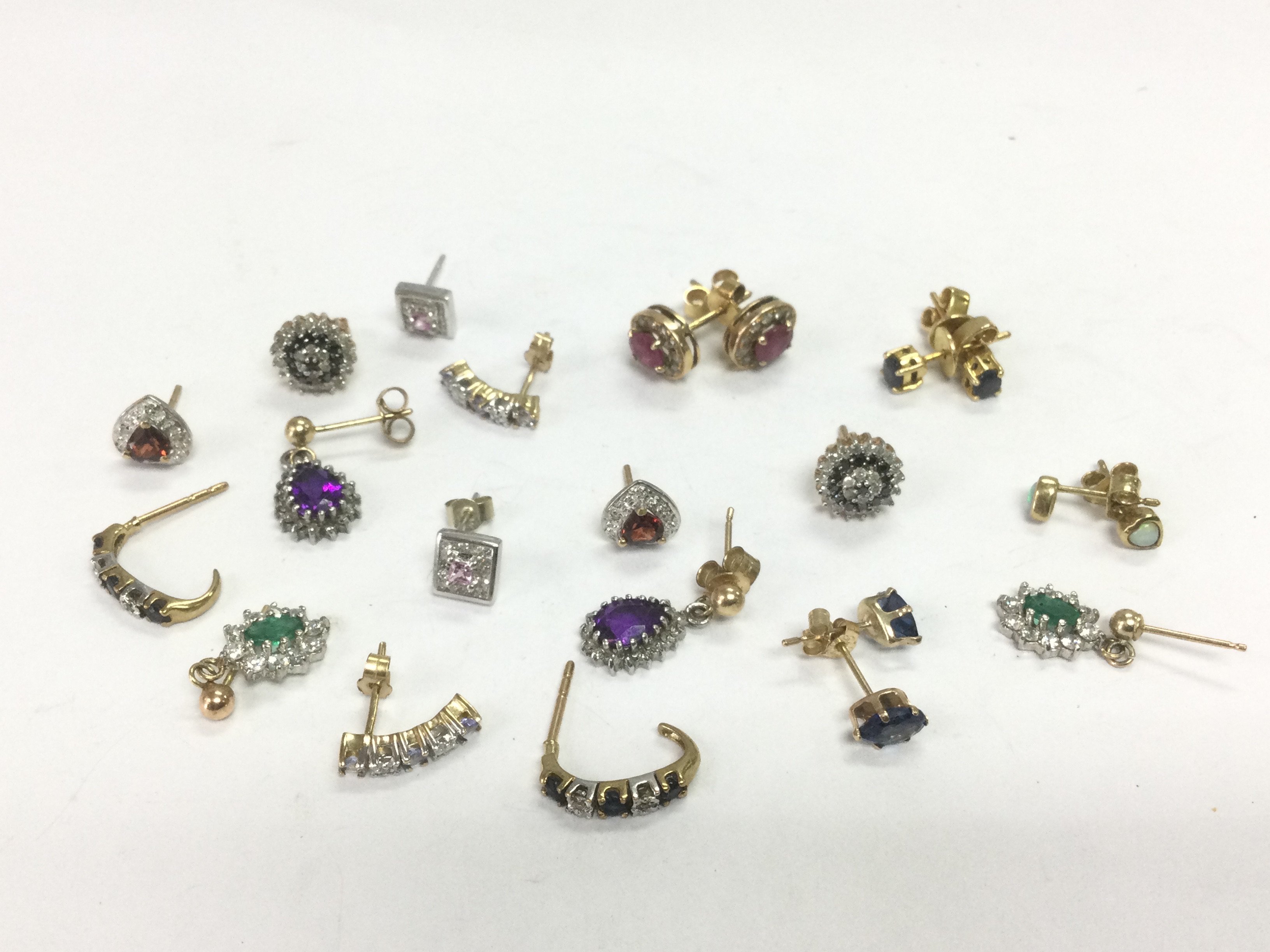 A collection of gold earrings set with diamonds and various coloured stones, total approx 13.7g. Shipping category A.