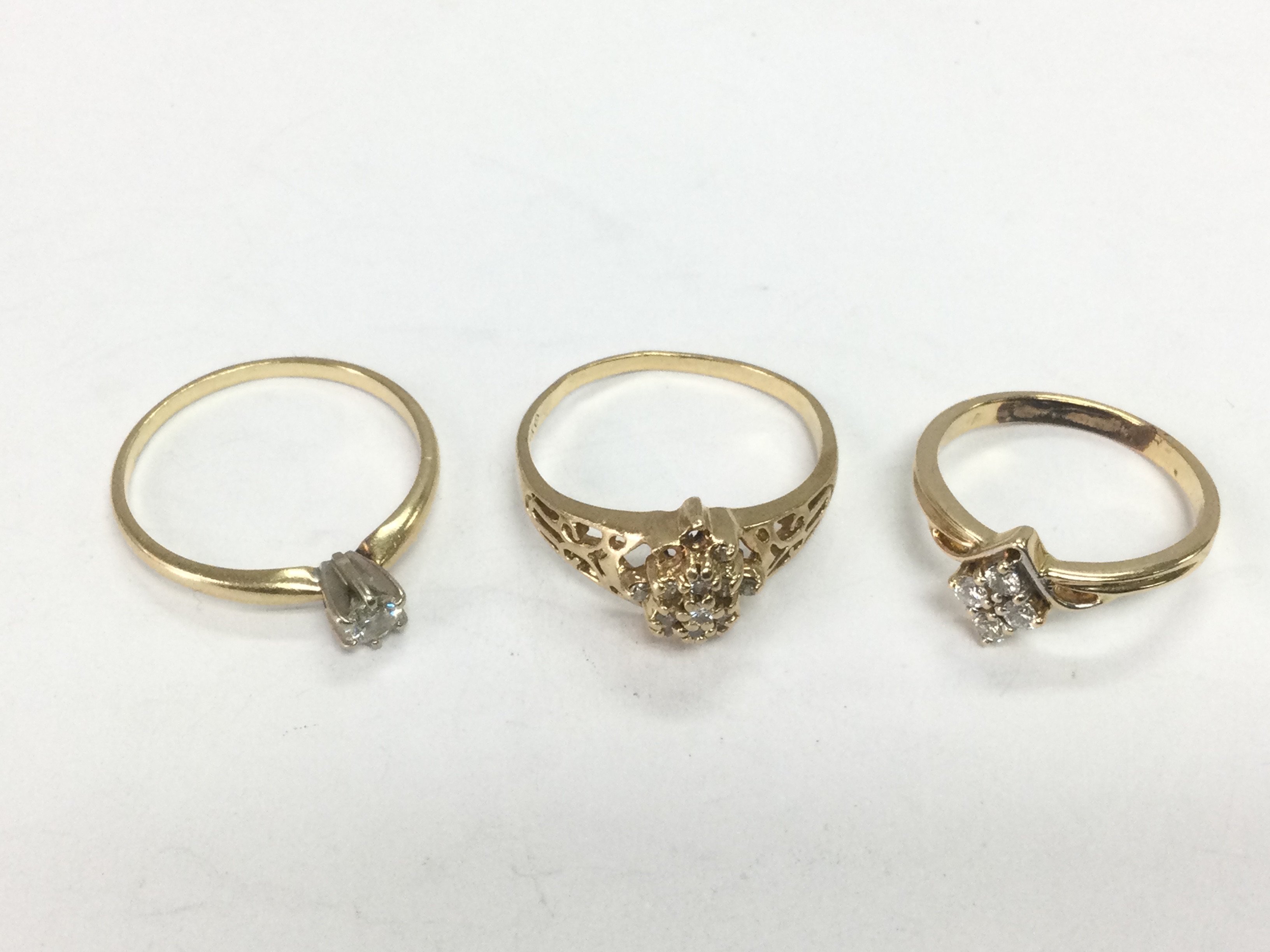 Three gold rings set with diamonds, two 14ct and one unmarked, approx sizes O-P, P and J. Total approx 6.5g. Shipping category A.
