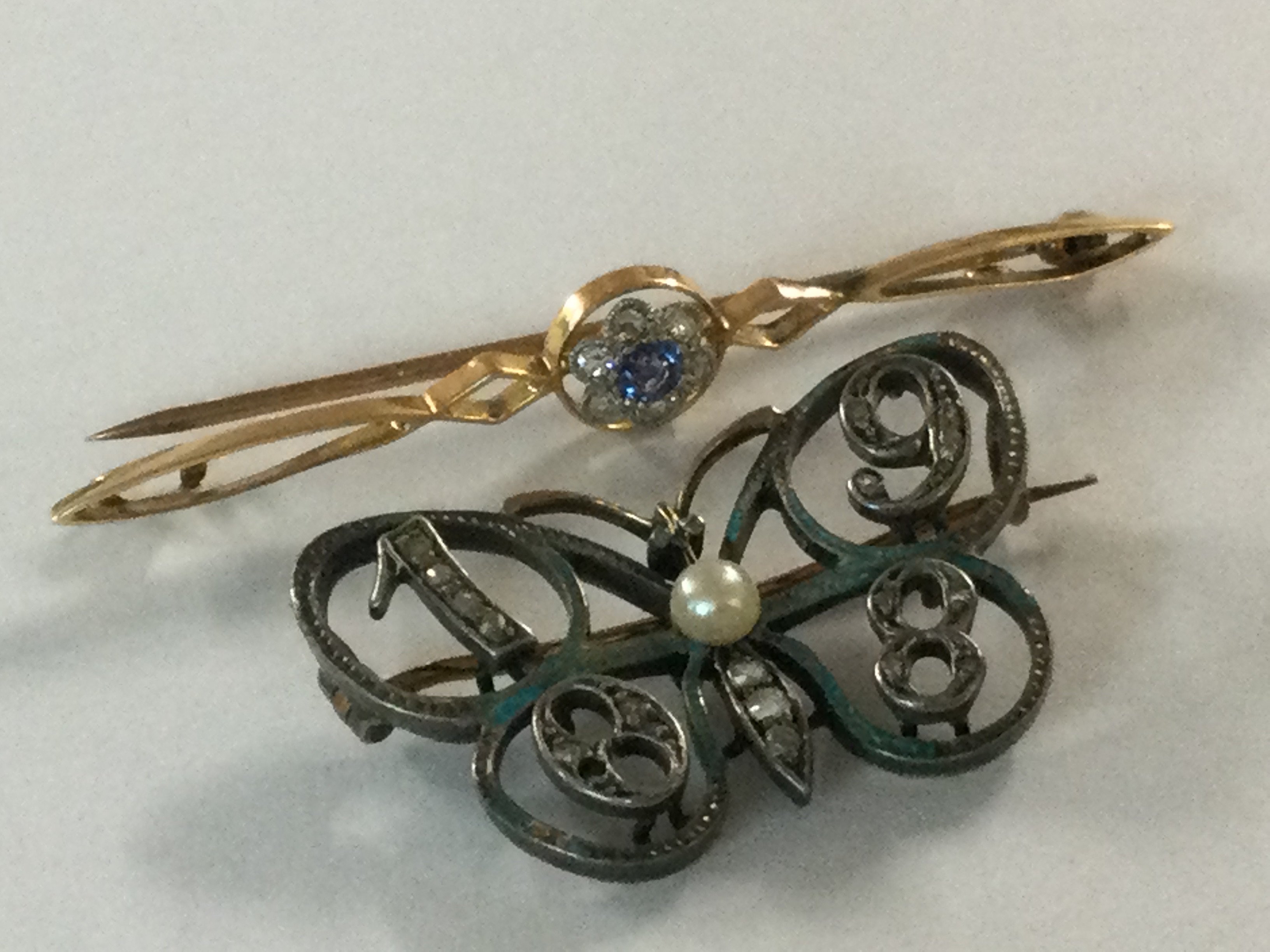 A 15ct gold brooch inset with small sapphire surround by diamond chips of floral design, together with a 1908 brooch in the form of a butterfly