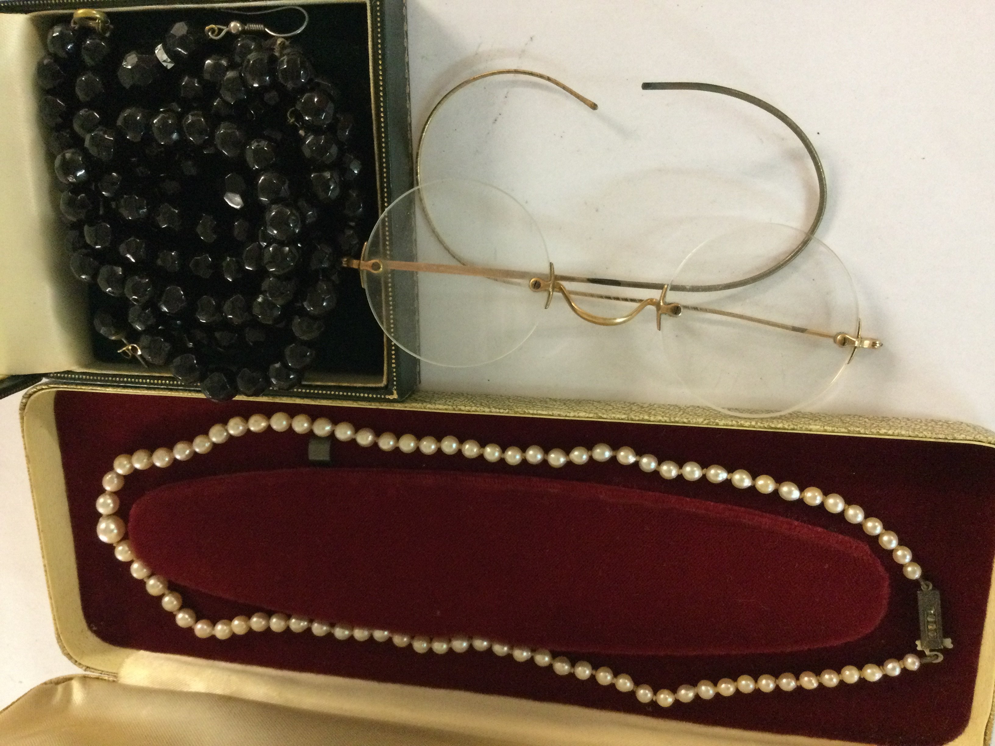 A jet style jade necklace, a pair of spectacles and a cultured pearl necklace