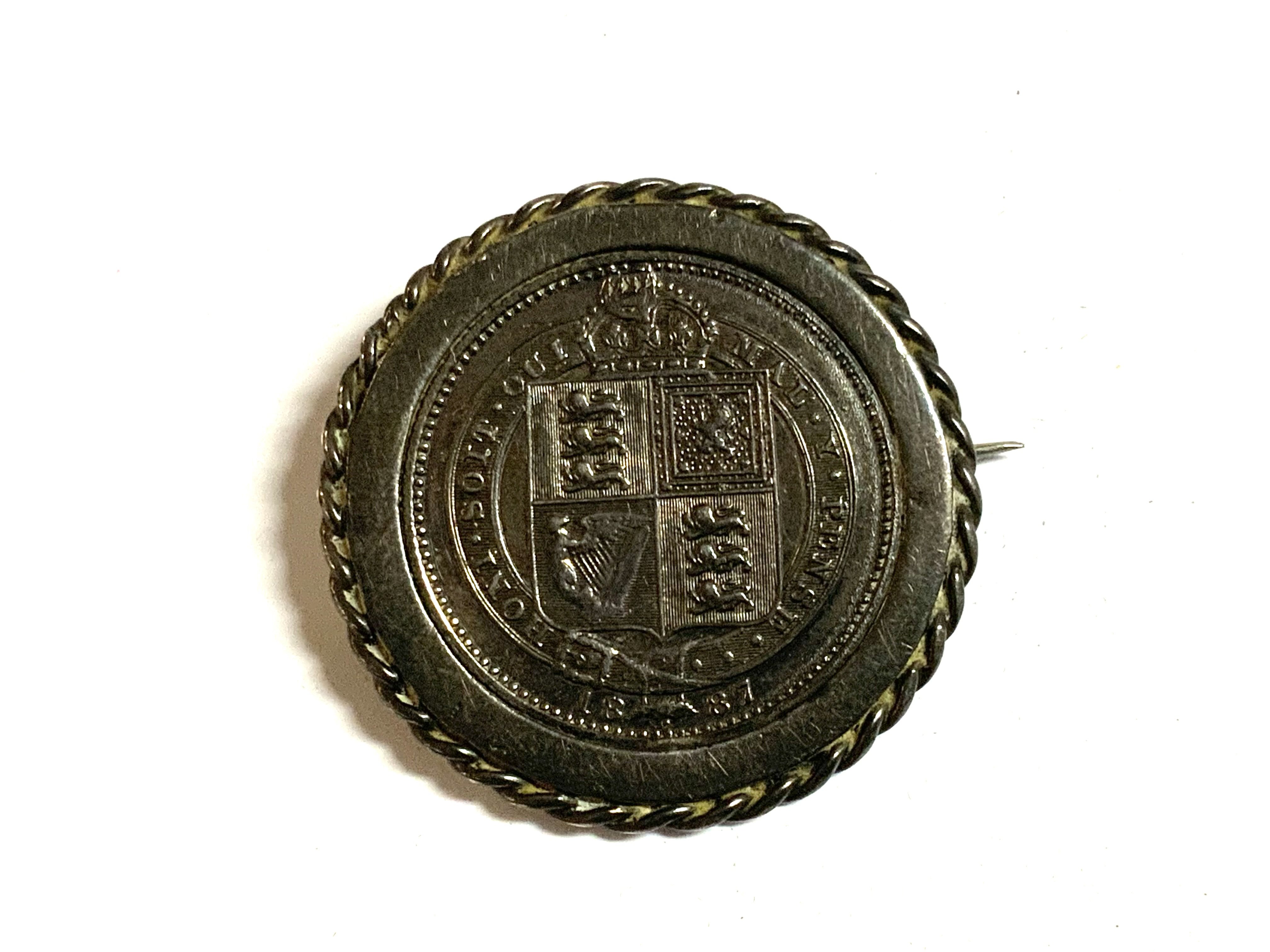 An 1887 Jubilee sixpence in silver brooch mount.