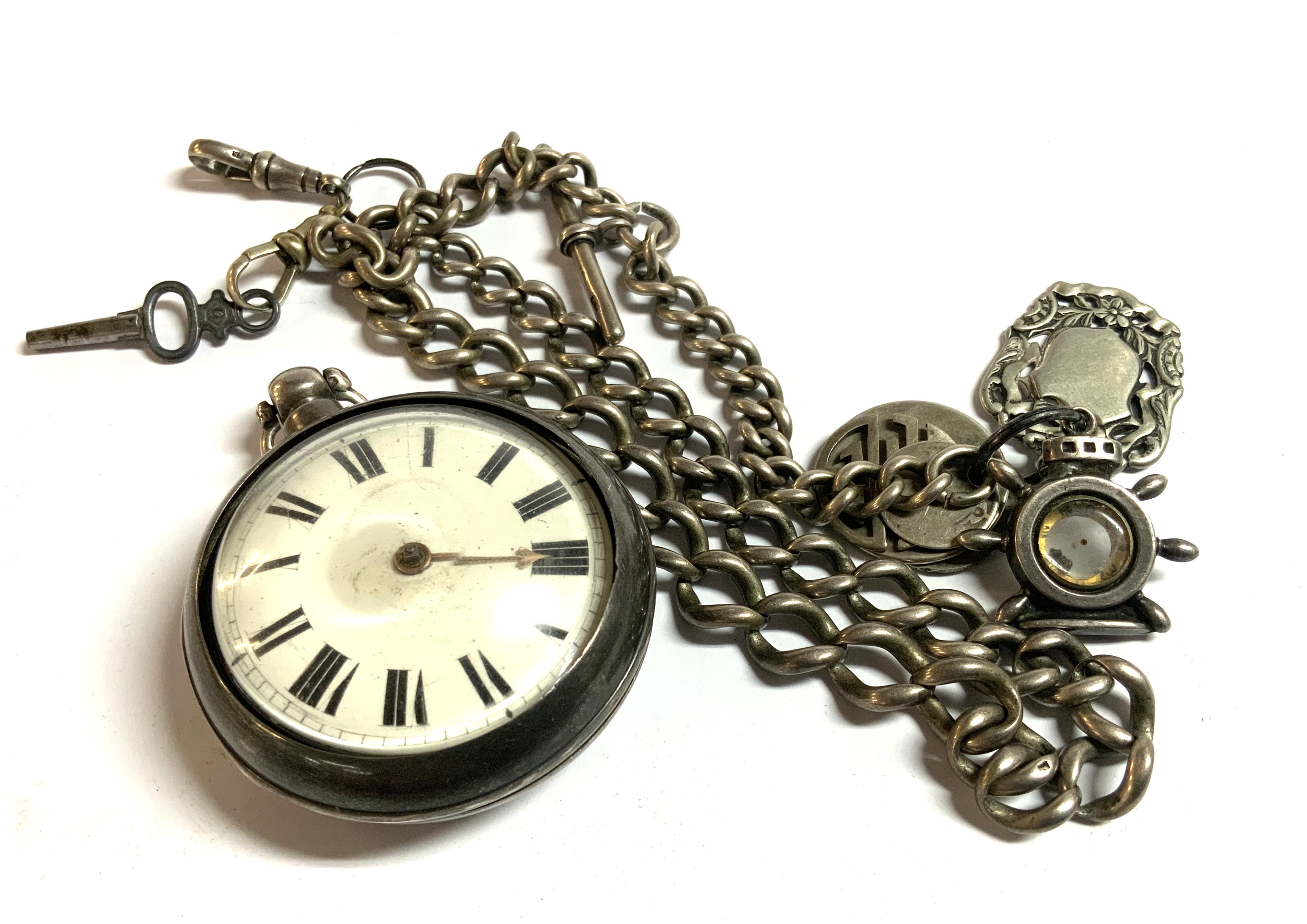 A heavy hallmarked silver Albert chain with a pair cased silver pocket watch and charms. (D)