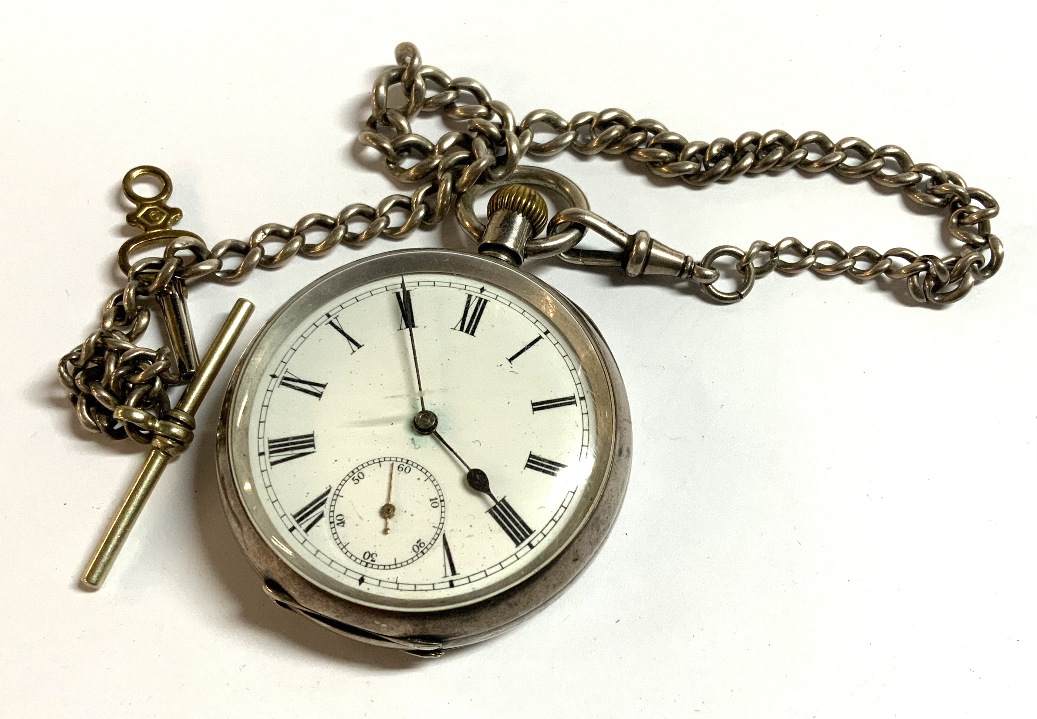 A hallmarked silver pocket watch with attached part silver Albert chain.