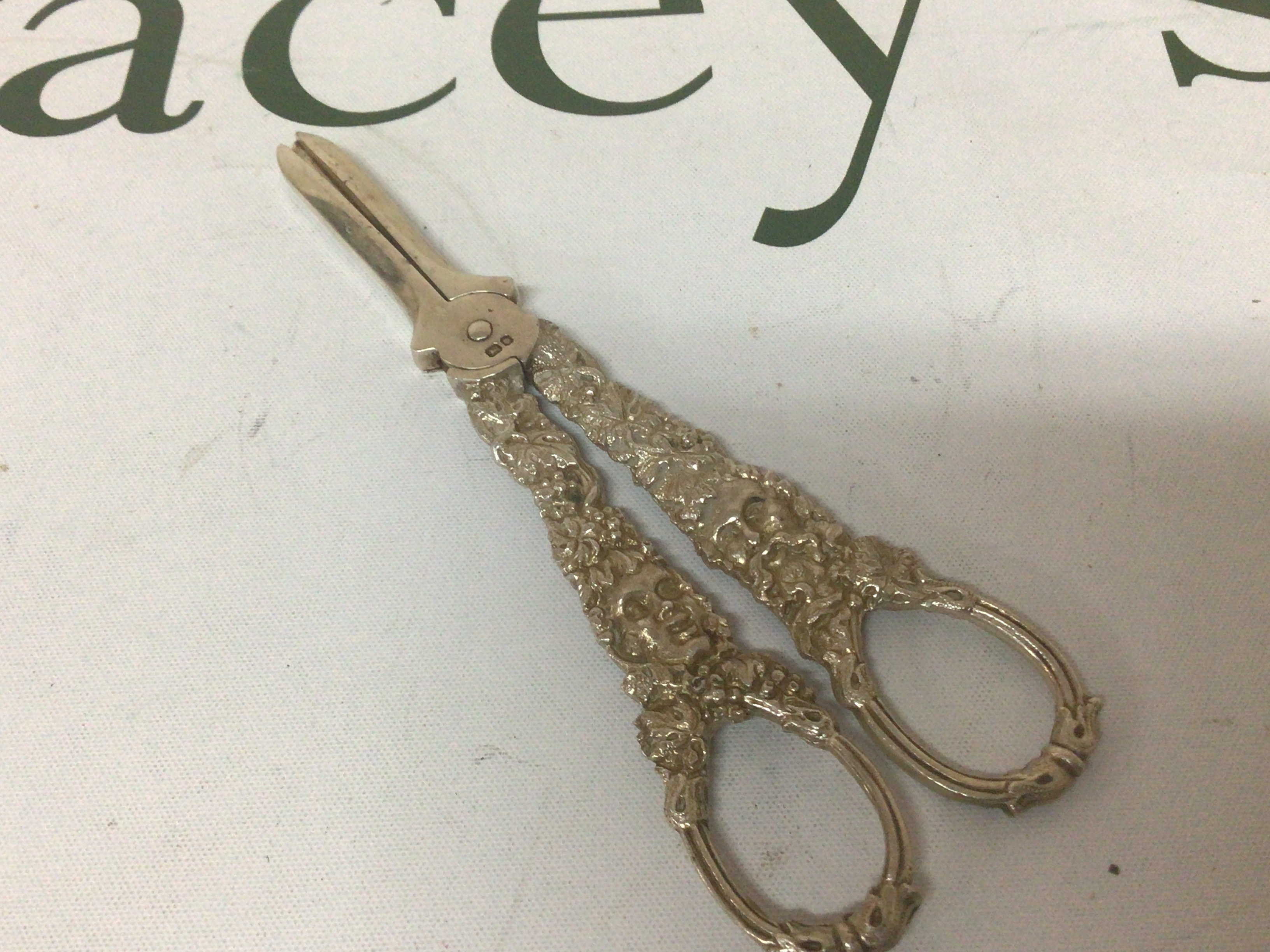 A pair of silver grape scissors with ornate cast handles. London hallmarks.