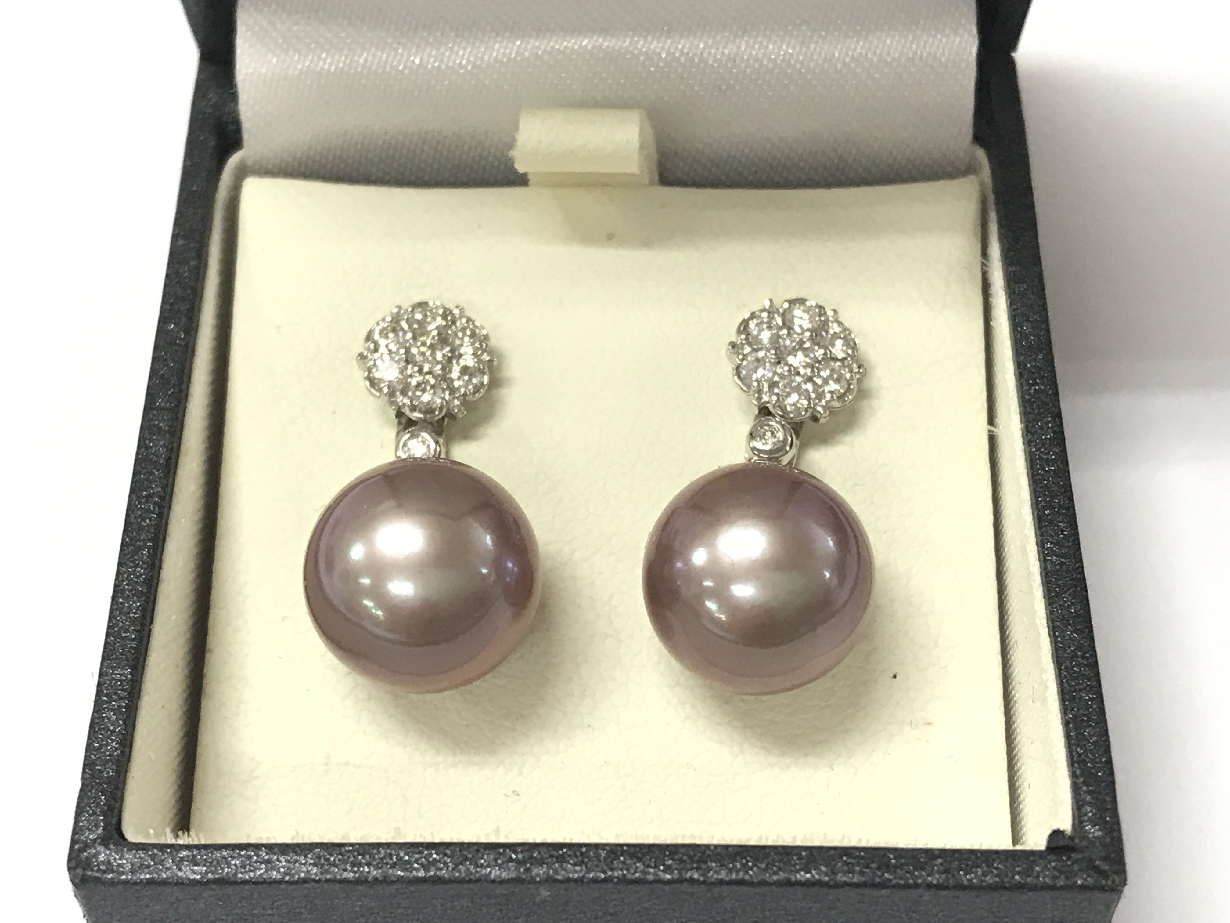 A pair of 18ct white gold earrings set with large pinkish grey pearls with detachable diamond daisy bales. Postage B