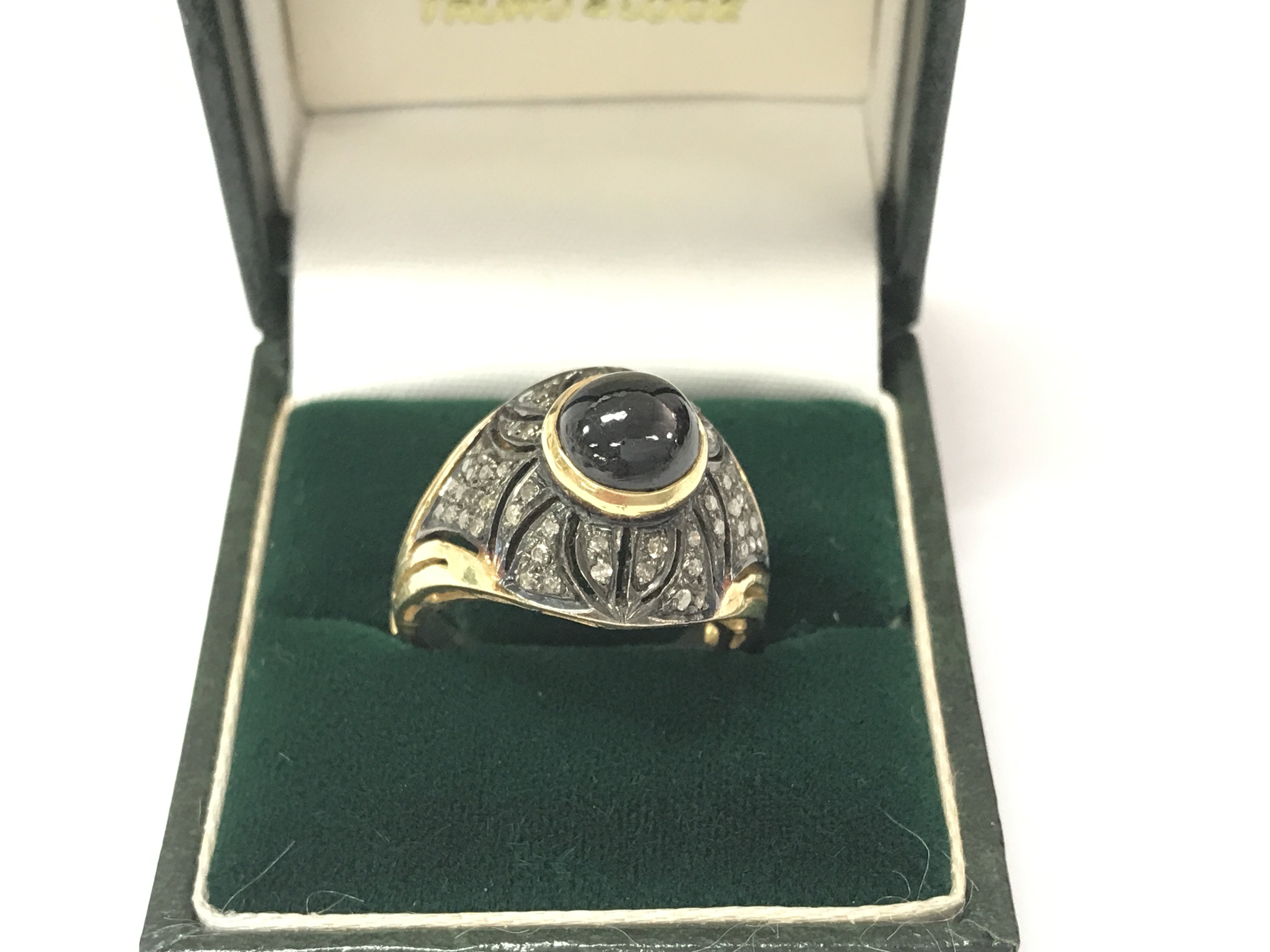 A silver gilt ring rubover set with a cabochon sapphire and several rose cut diamonds. Sapphire 3.58ct and diamonds 0.41ct. Size N