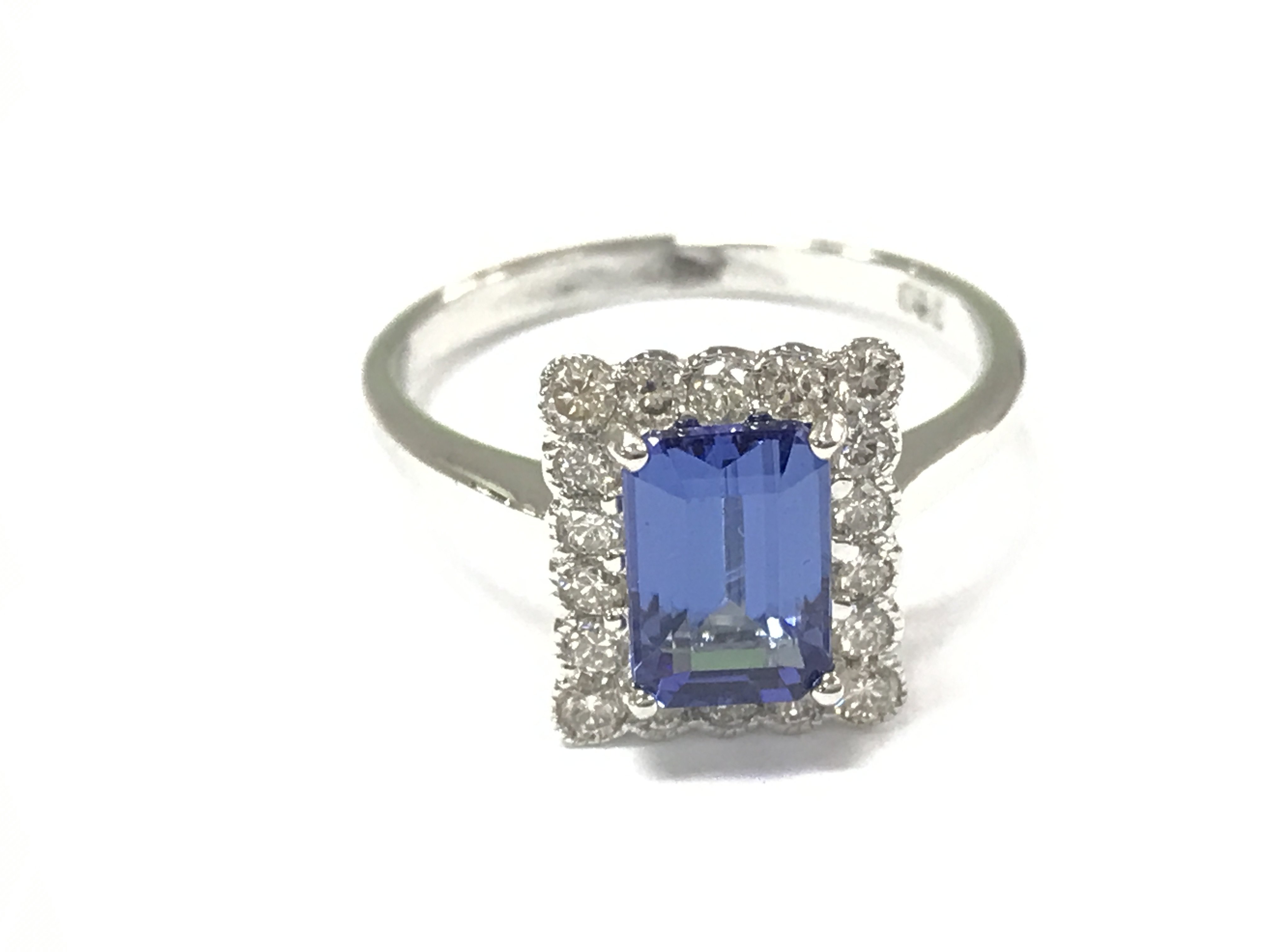 An 18ct white gold ring with emerald cut tanzanite and round cut diamonds. Tanzanite 1.40ct and 0.40ct diamonds approximately. Size M