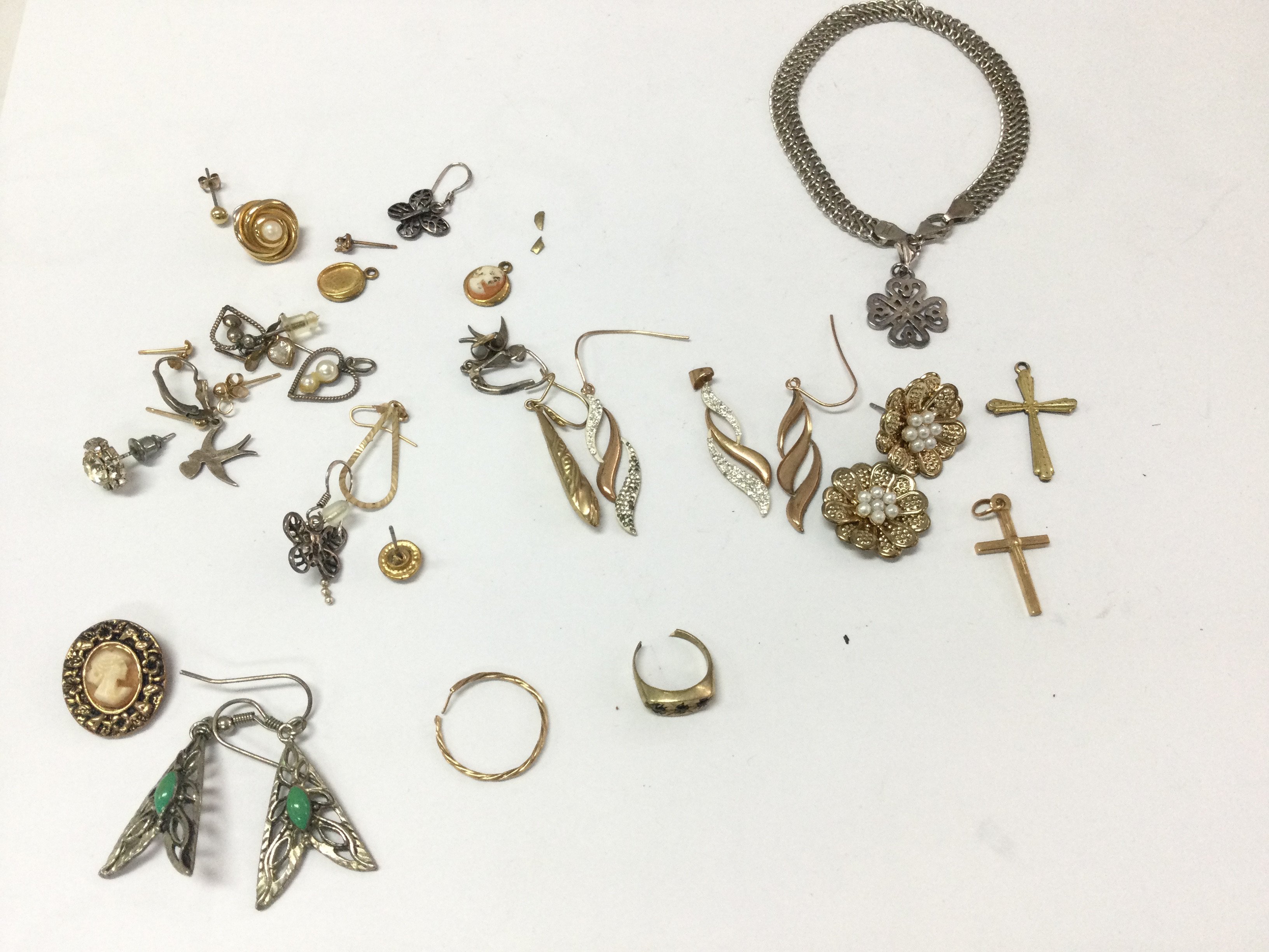 A collection of earrings and pendants including gold and silver examples.