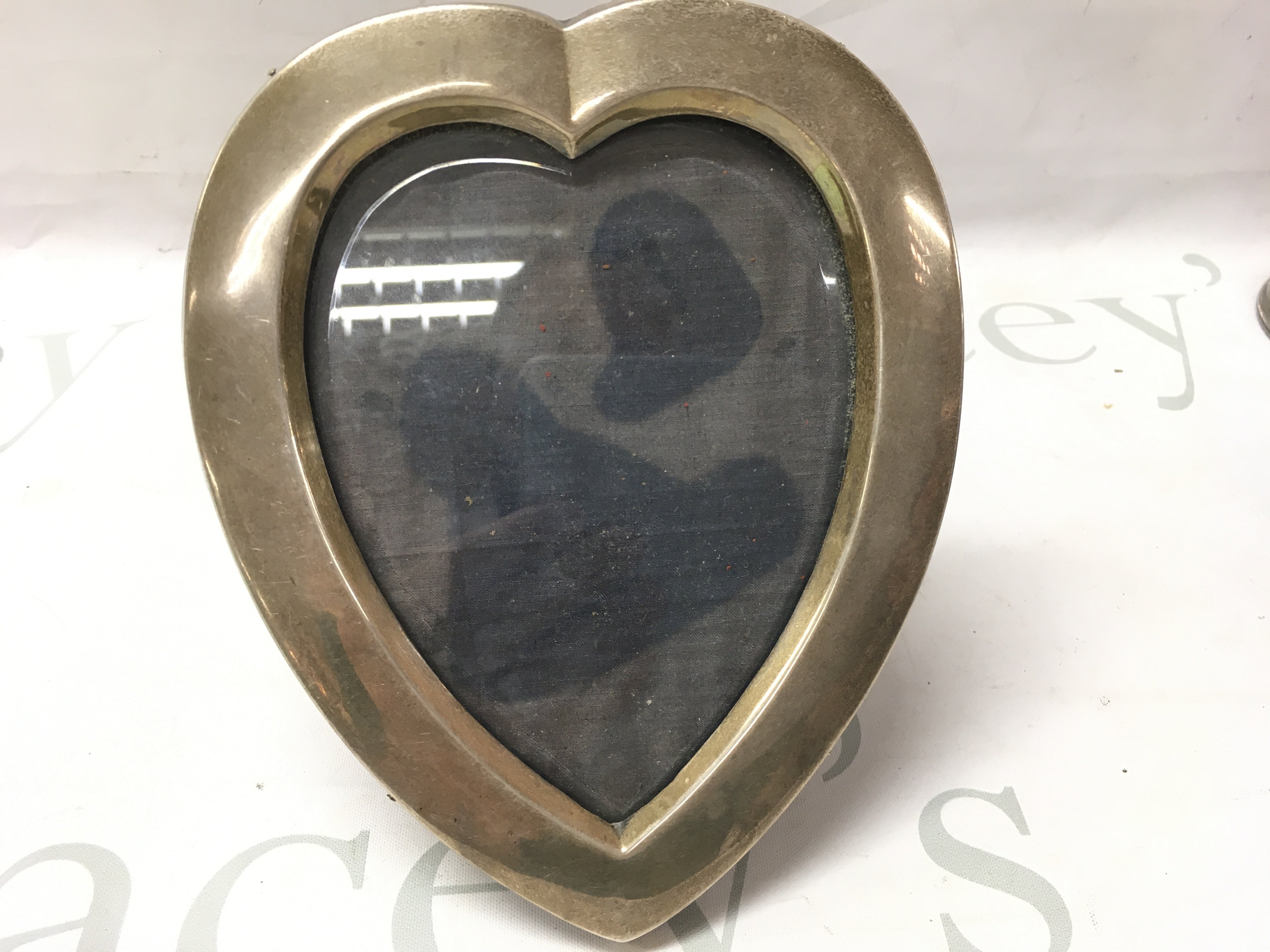 A silver heart shaped photo frame. Postage B
