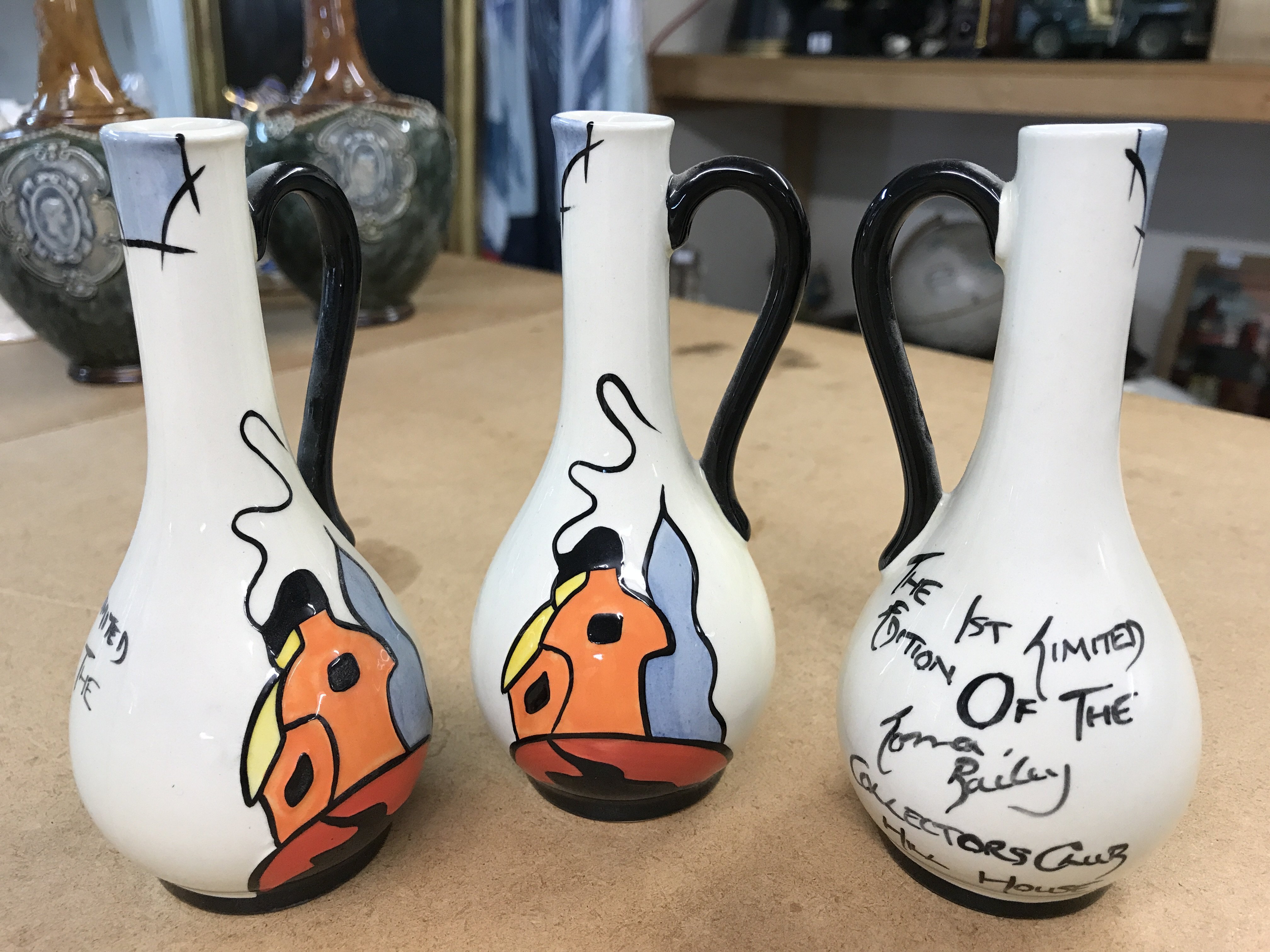 Three Lorna Bailey pieces with the words "The 1st Limited Edition of The Lorna Bailey Collectors Club Hill House" on each of the small jugs. Each 14cm in height