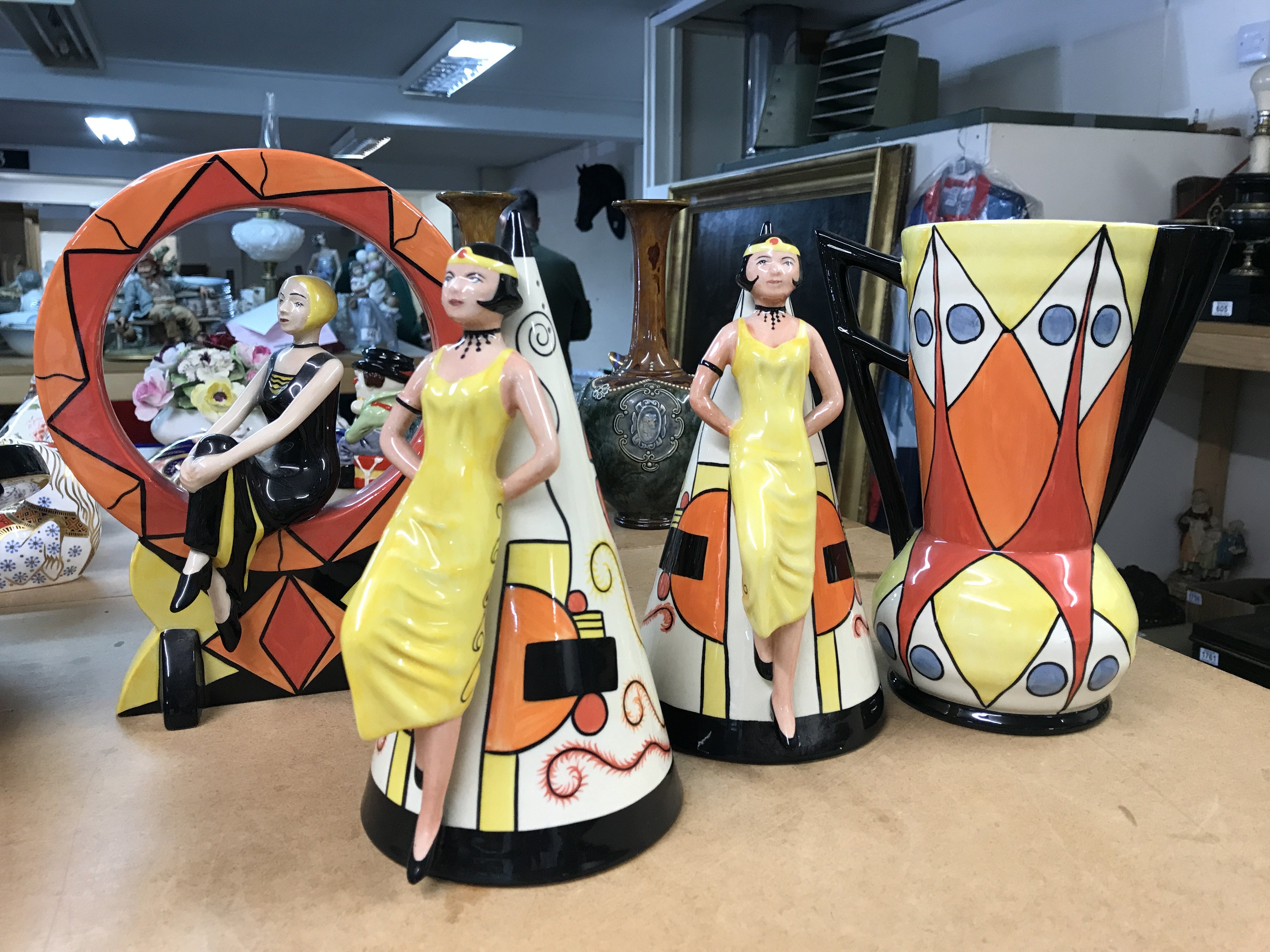 Four Lorna Bailey pottery pieces to include limited edition 1920,s girl seated in a hoop- 87/100, two large Art Deco style sugar shakers with raised figures 249/350 and 313/350 and an Art Deco style jug, decorated with geometric pattern - limited edition 18/150