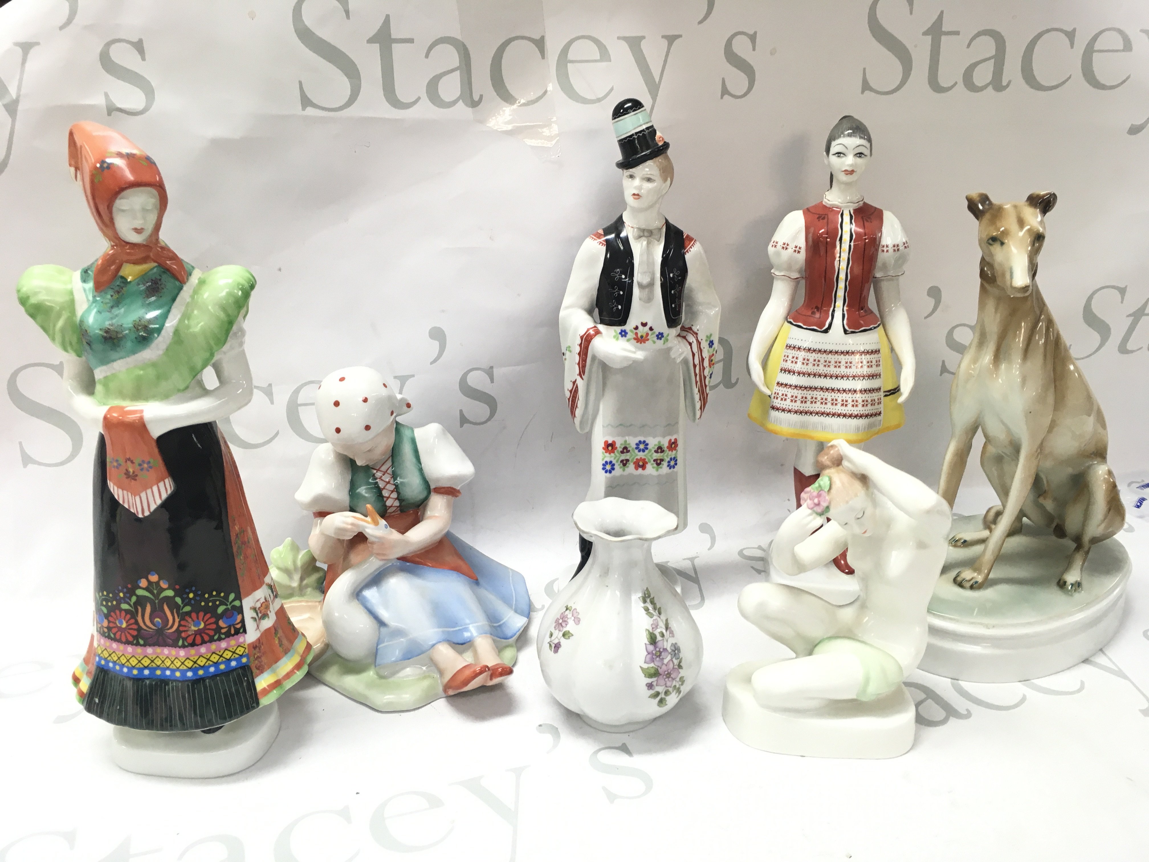 Hungarian Hollohaza, Zsolnav Pecs, Aquincum Budapest porcelain figures. Figures include Hungarian couple, greyhound figure, woman figure, child with goose , vase etc This lot cannot be posted