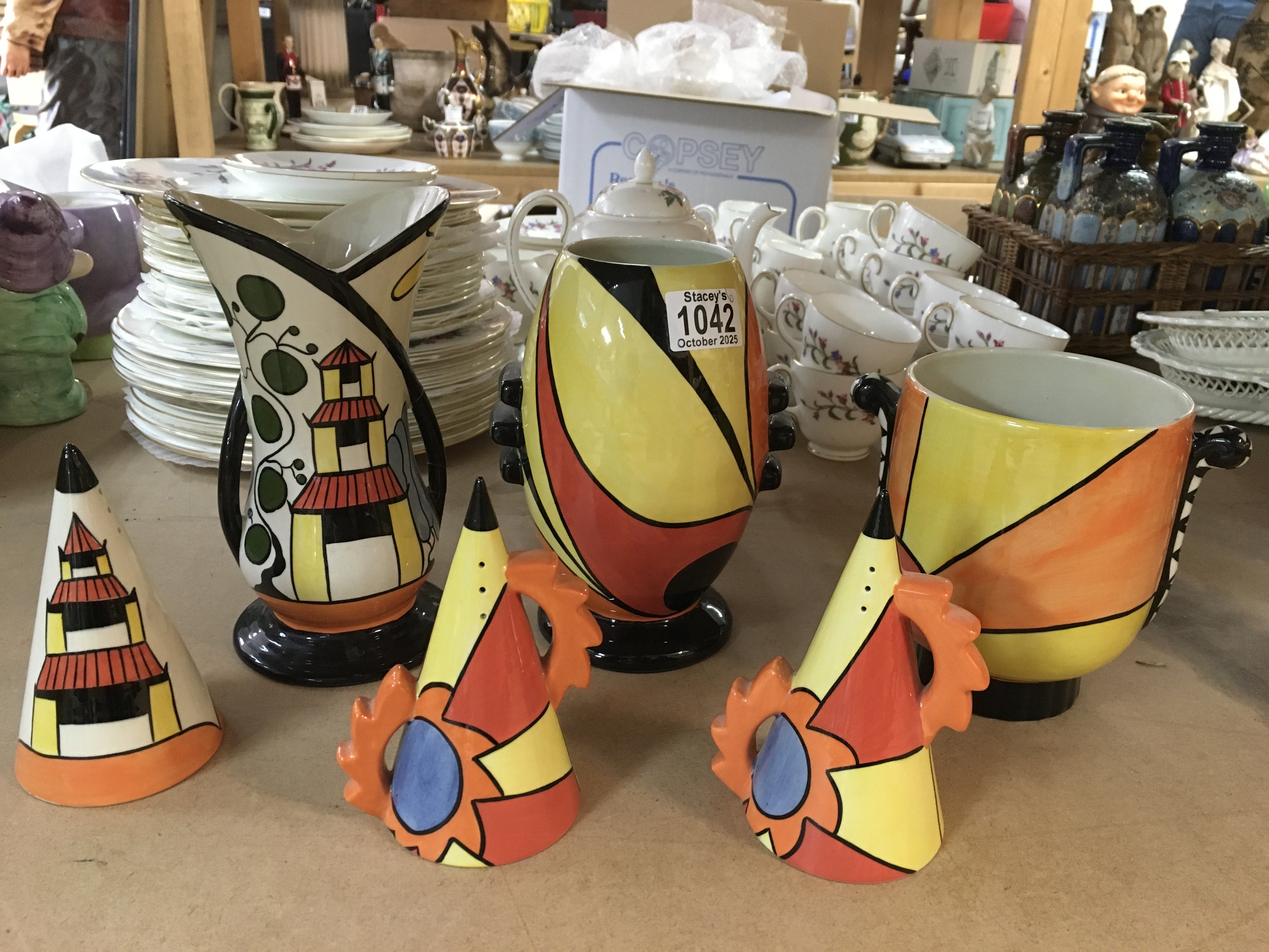 A Lorna Bailey "Flame" vase, a "Pagoda Garden" vase and sugar shaker, a "Sunburst" vase, and two other sugar shakers