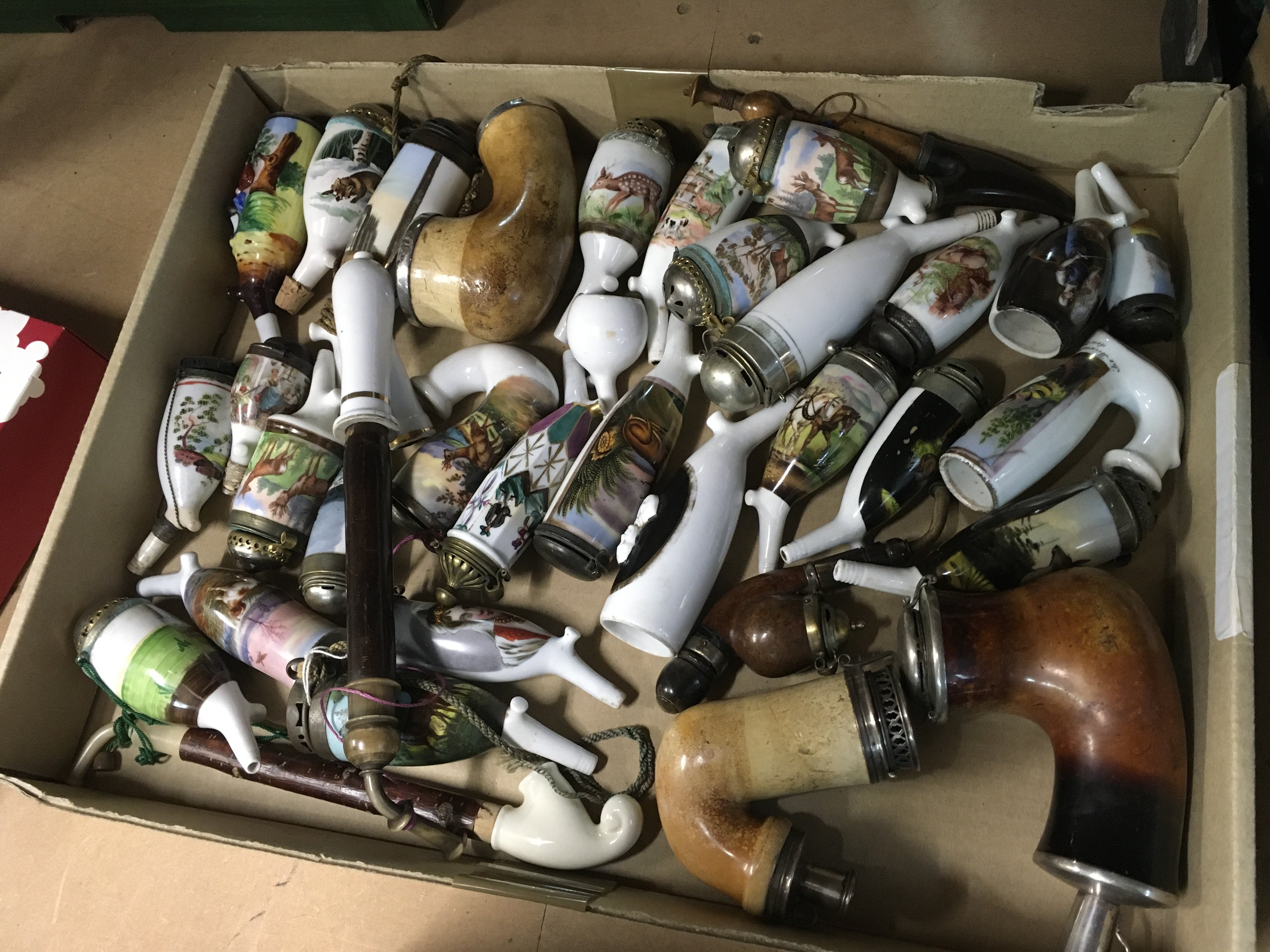 A Collection of porcelain pipes decorated with various country side scenes.