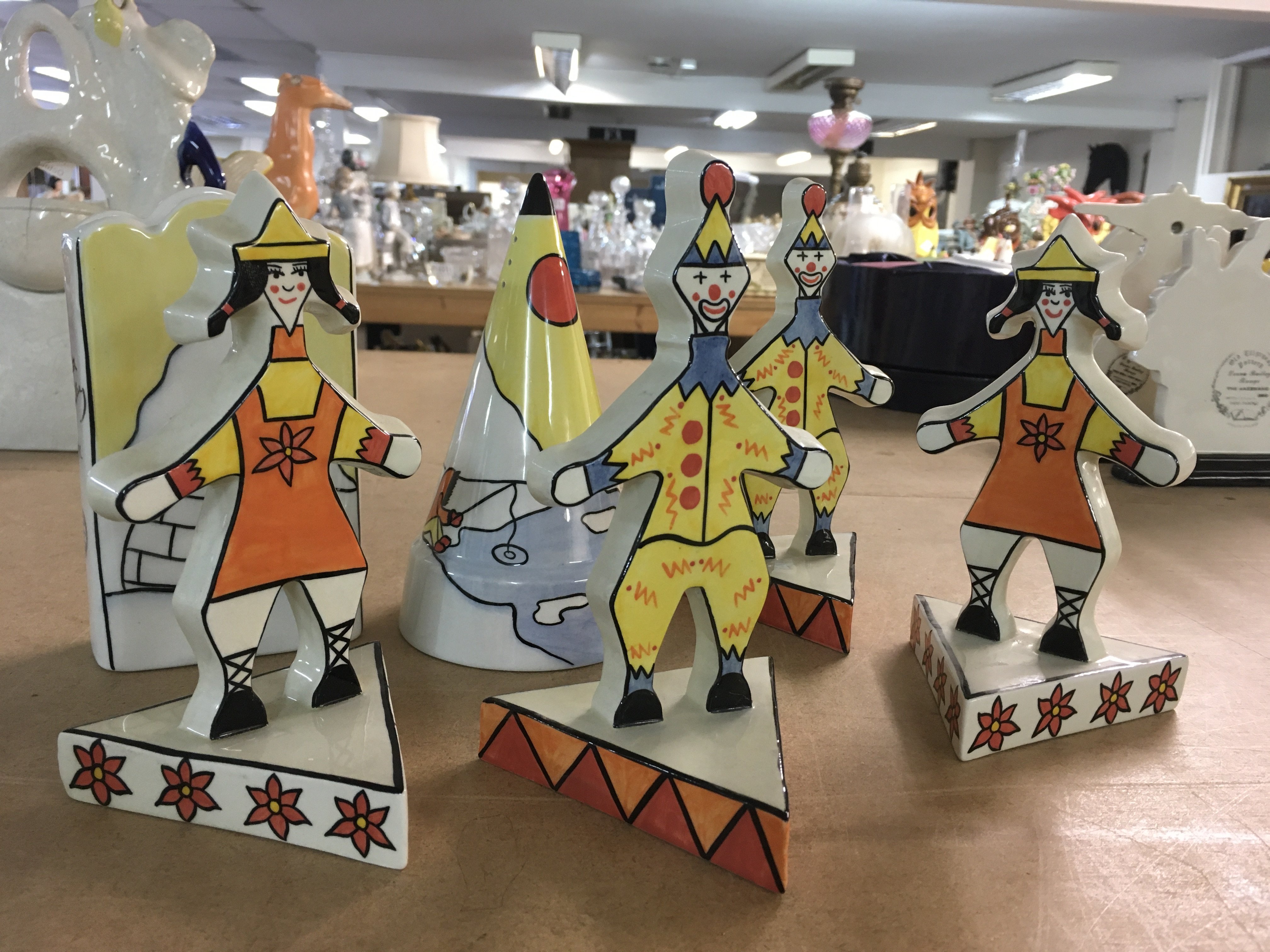 Six Lorna Bailey pieces, to include Artic pattern vase and sugar shaker and four limited edition circus figure flat-backs