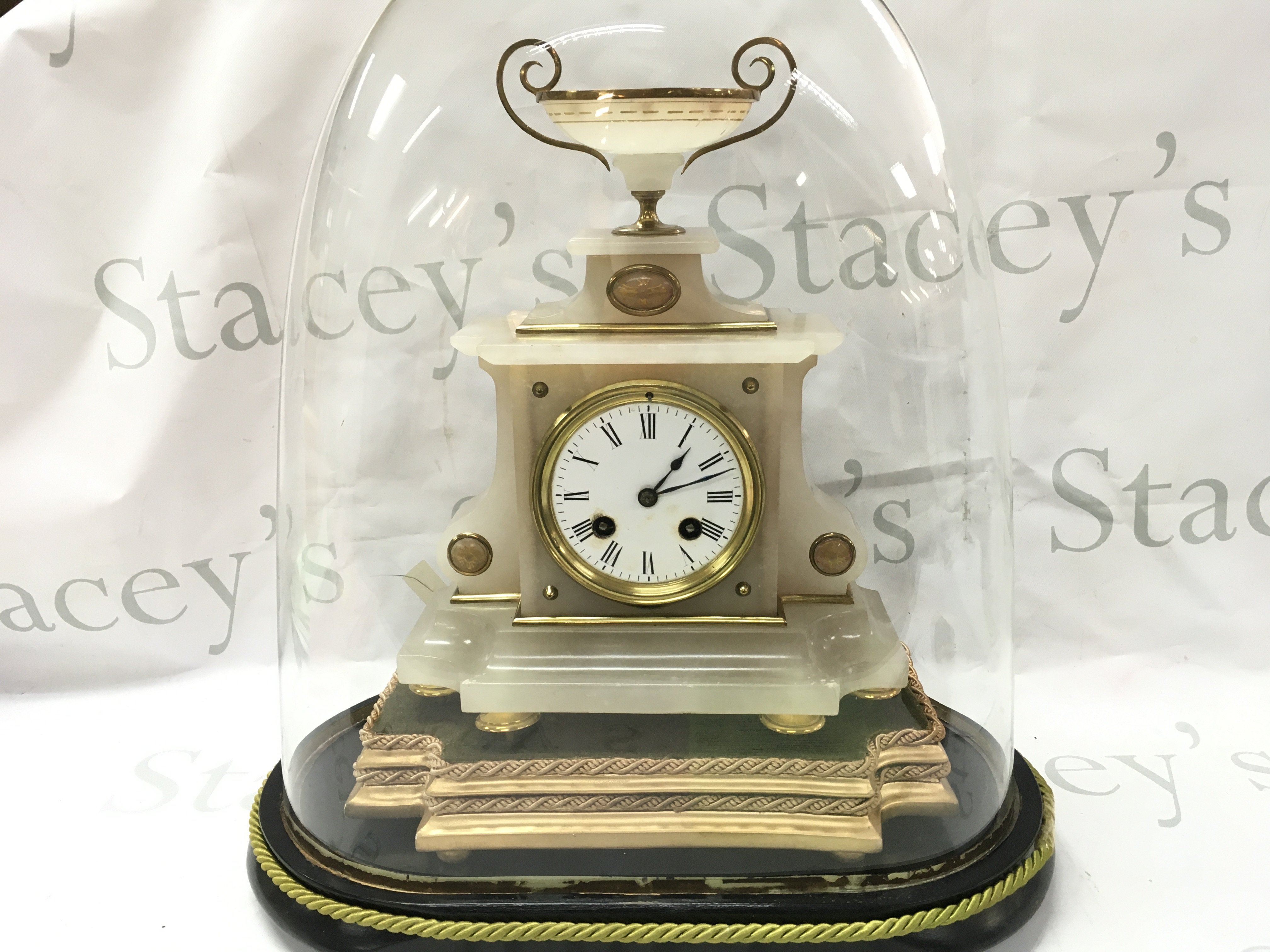 An Alabaster mantle clock with gilt mounts under dome. With key and pendulum .Clock 29cm tall 22.5cm wide. Dome 40cm tall.