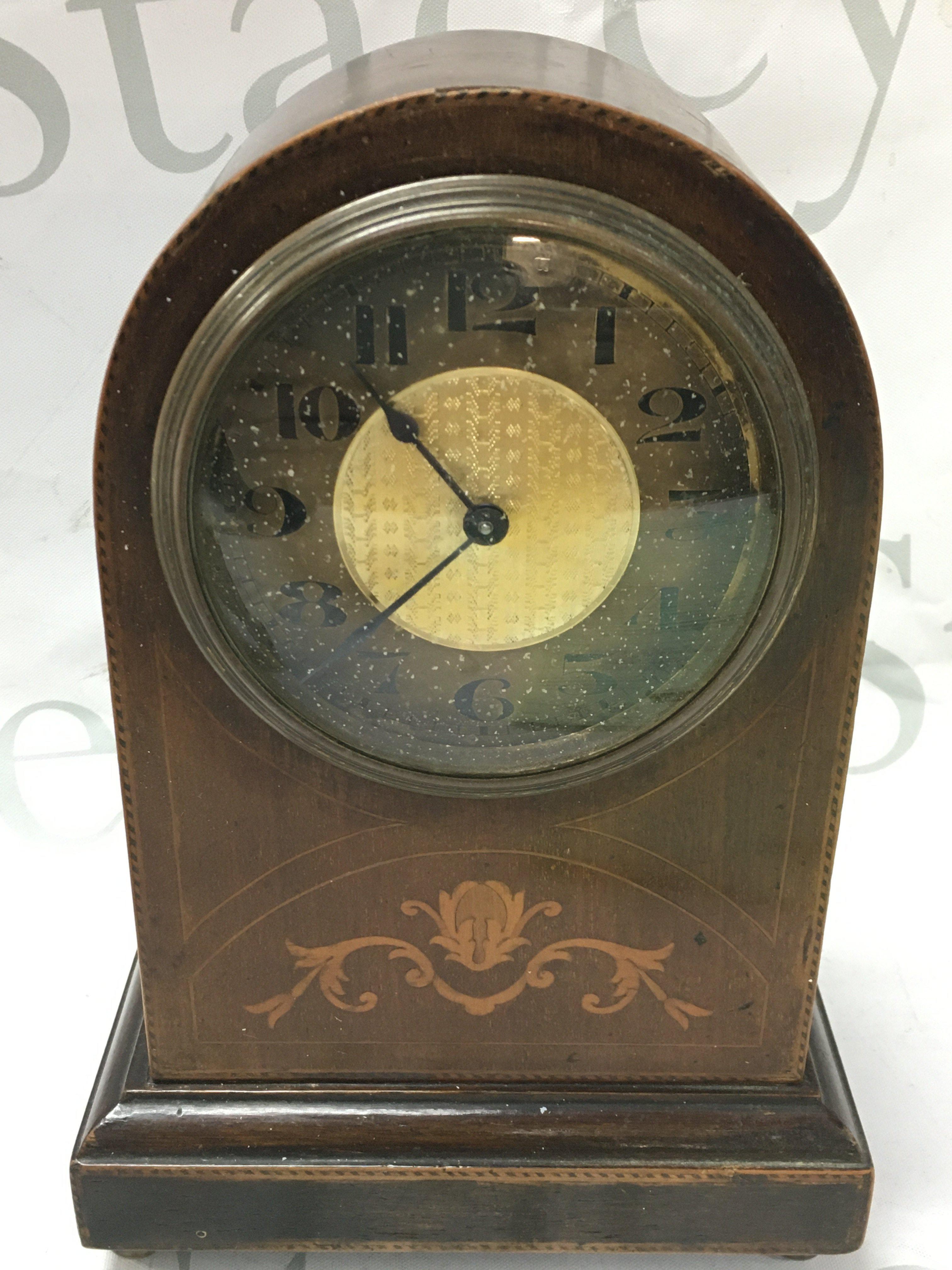 A small inlaid design mantle clock with a Buren Swiss movement. 22cm tall