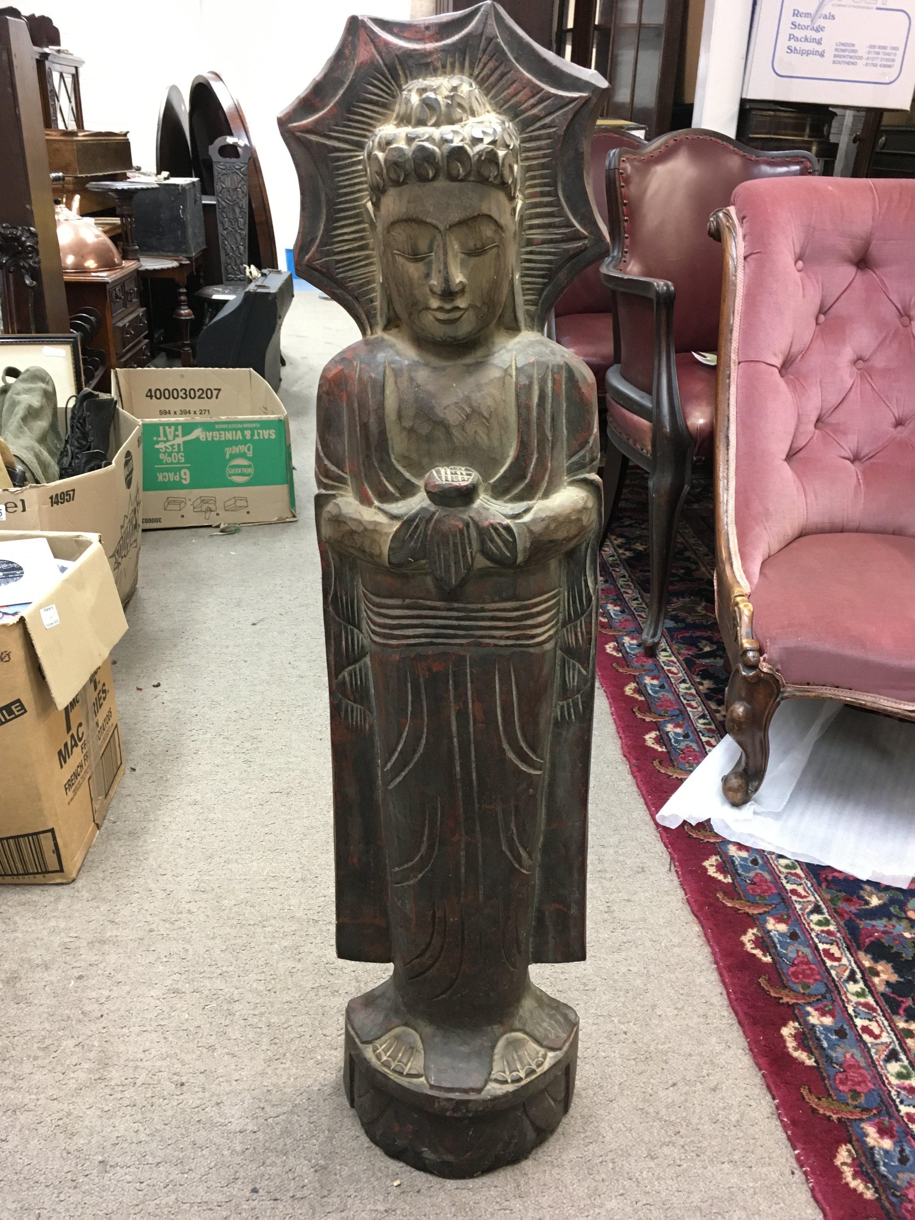 A wooden carved standing buddha. Approx 102cm tall.