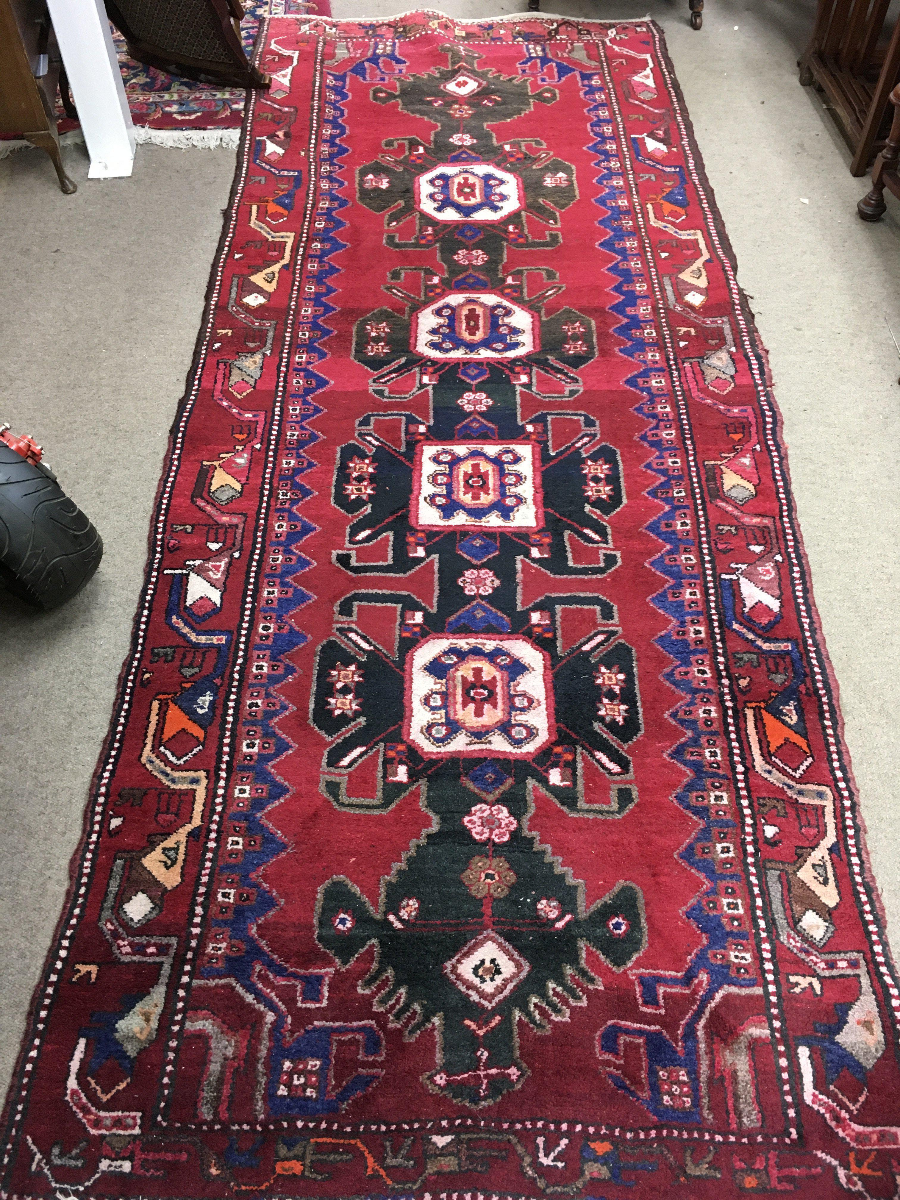 A Persian wool rug. Approx measurements 295x109cm.