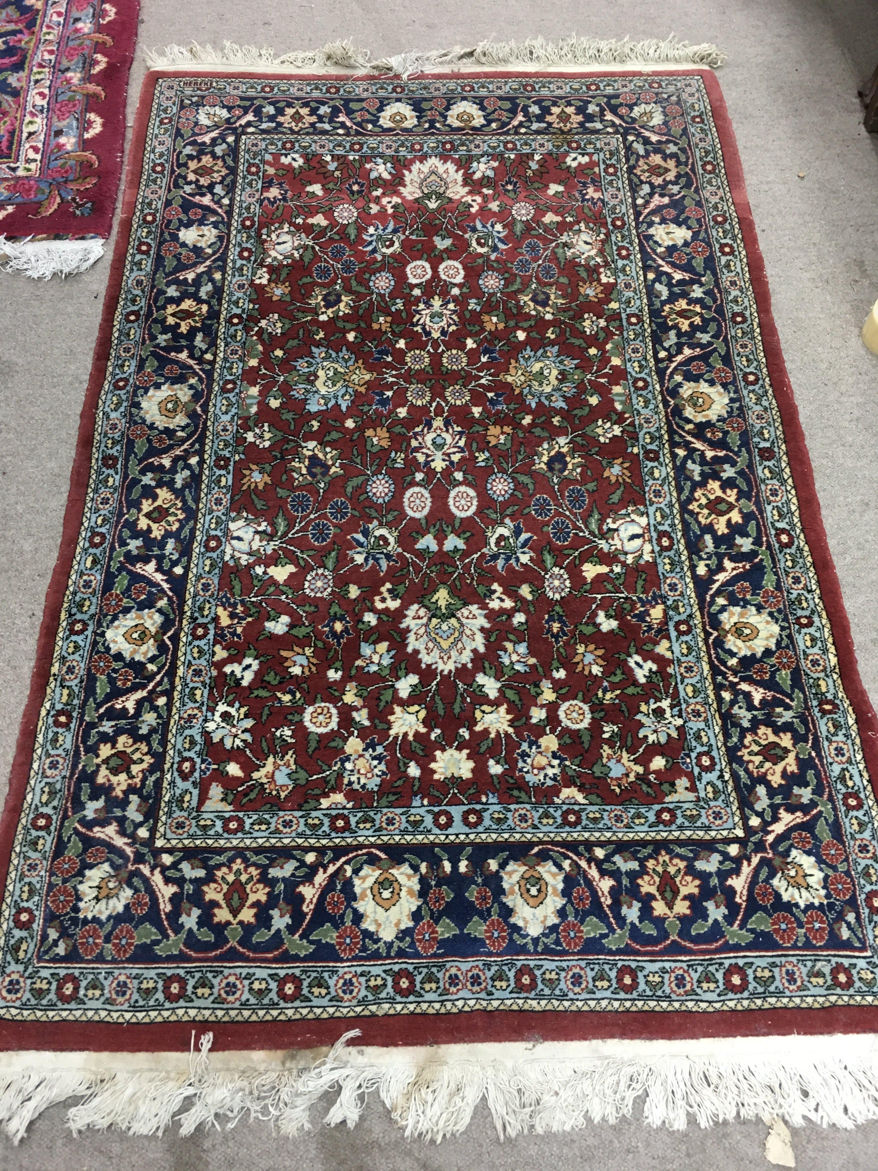 A Persian wool rug with floral patterns. Approx measurements 162x101cm.