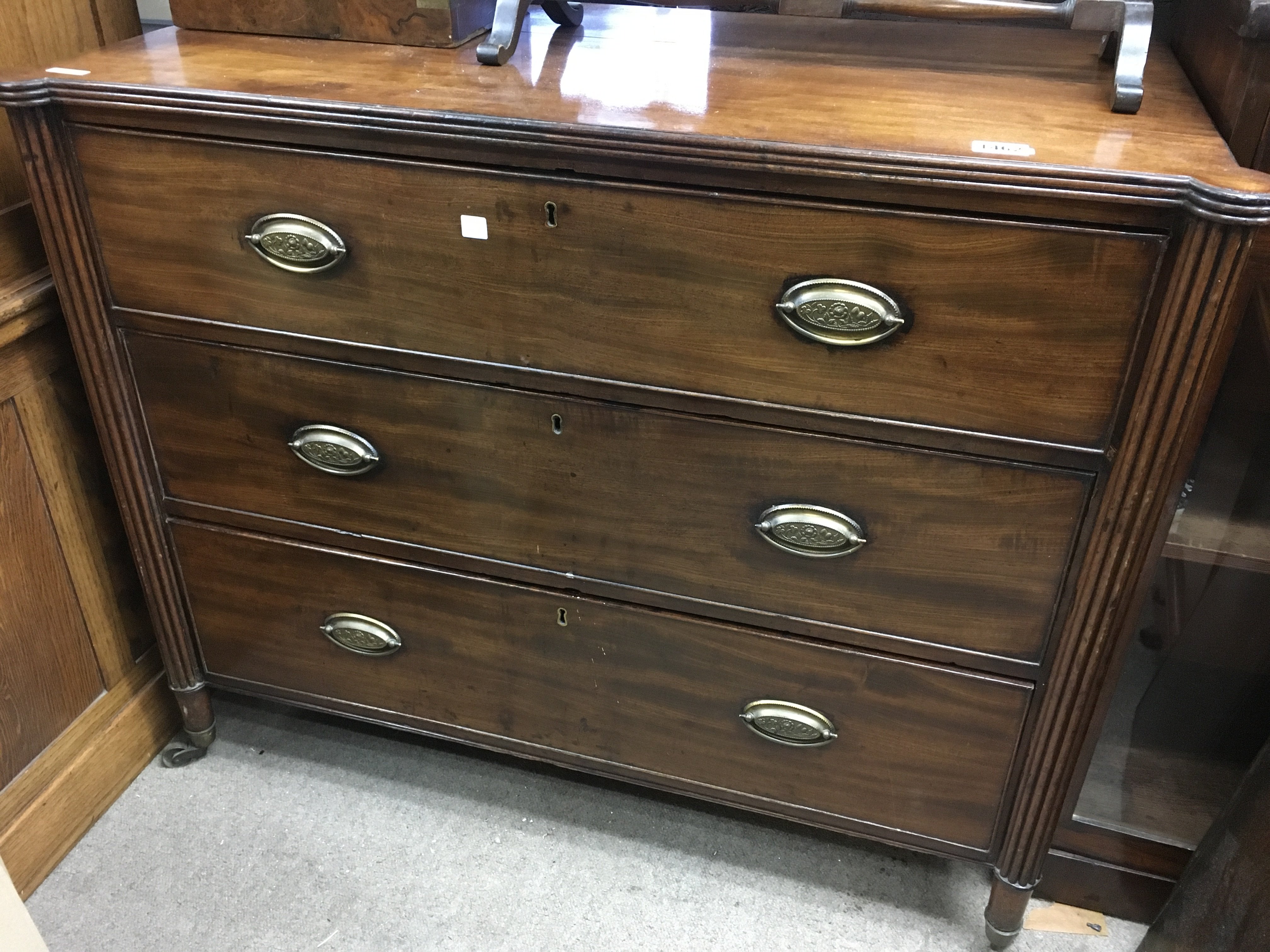 A mahogany Regency style chest of drawers. The rectangular top above three drawers, flanked by pillar supports. 100cm x 52cm