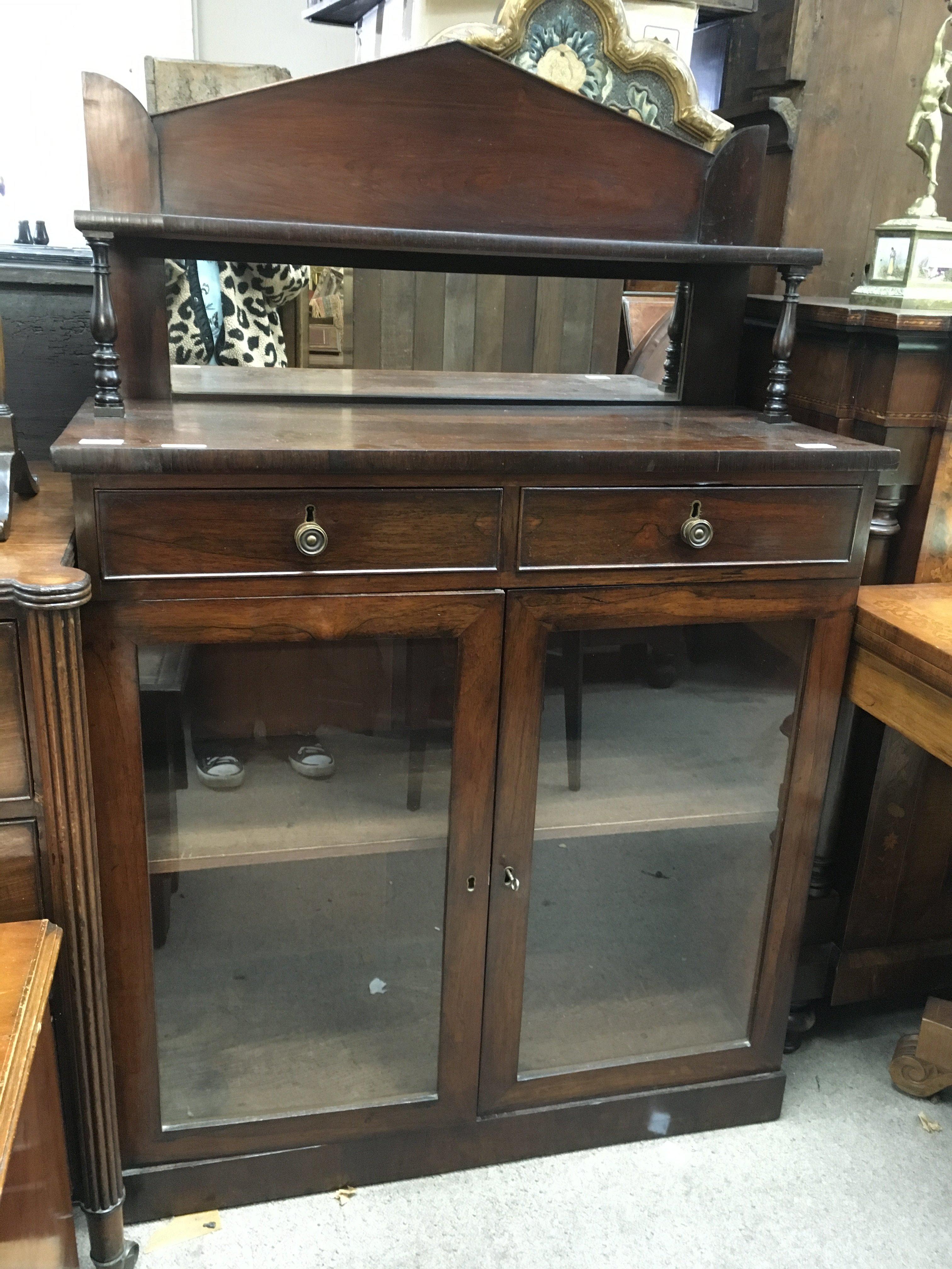 A Victorian mahogany chiffonier, the raised back above two drawers and a pair of glazed doors in a plinth base. 90cm x 40cm