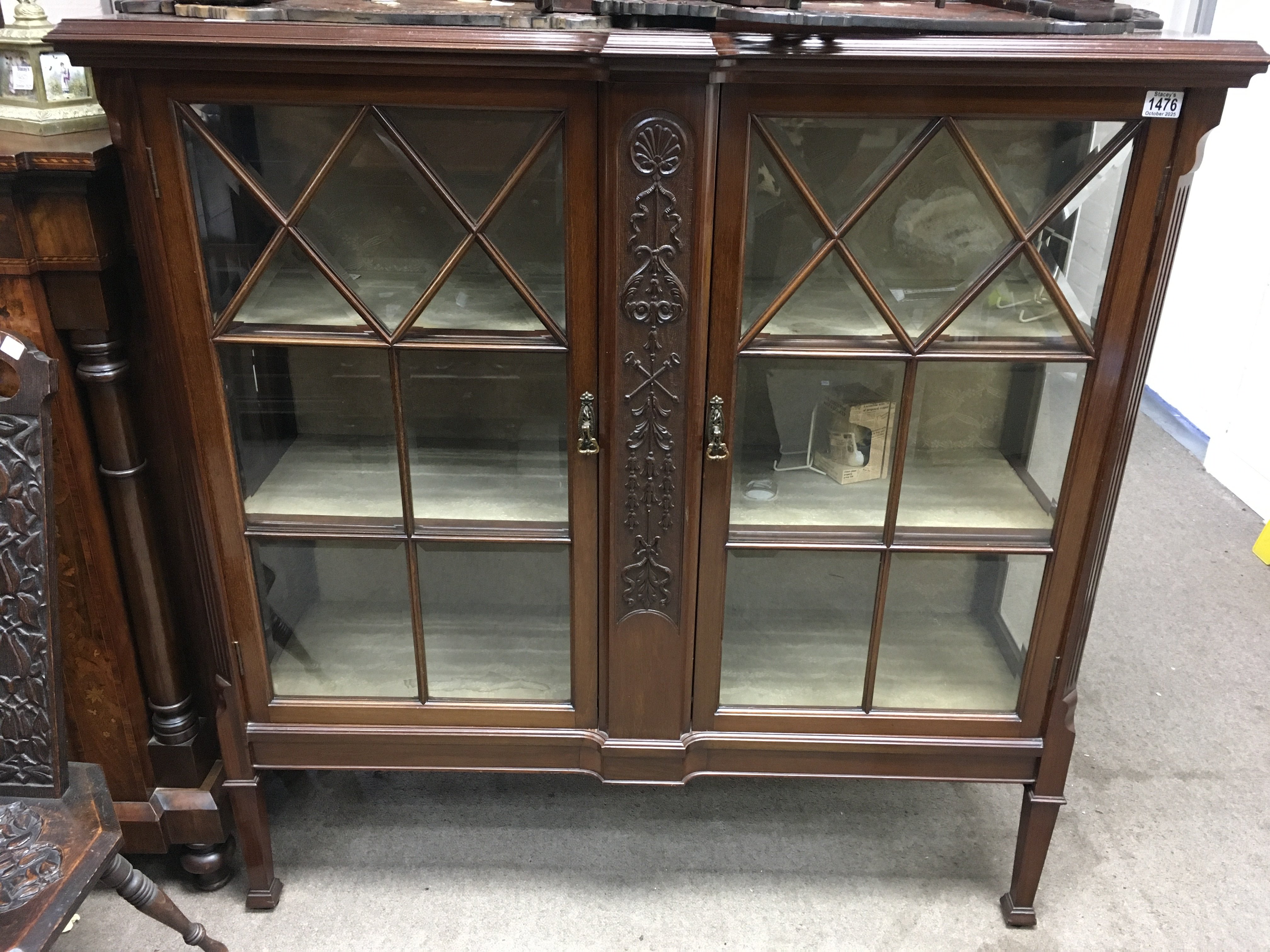 An Edwardian mahogany display cabinet with a pair of glazed doors inclosing shelves on square tapering legs. 130cm x 122cm x 40cm