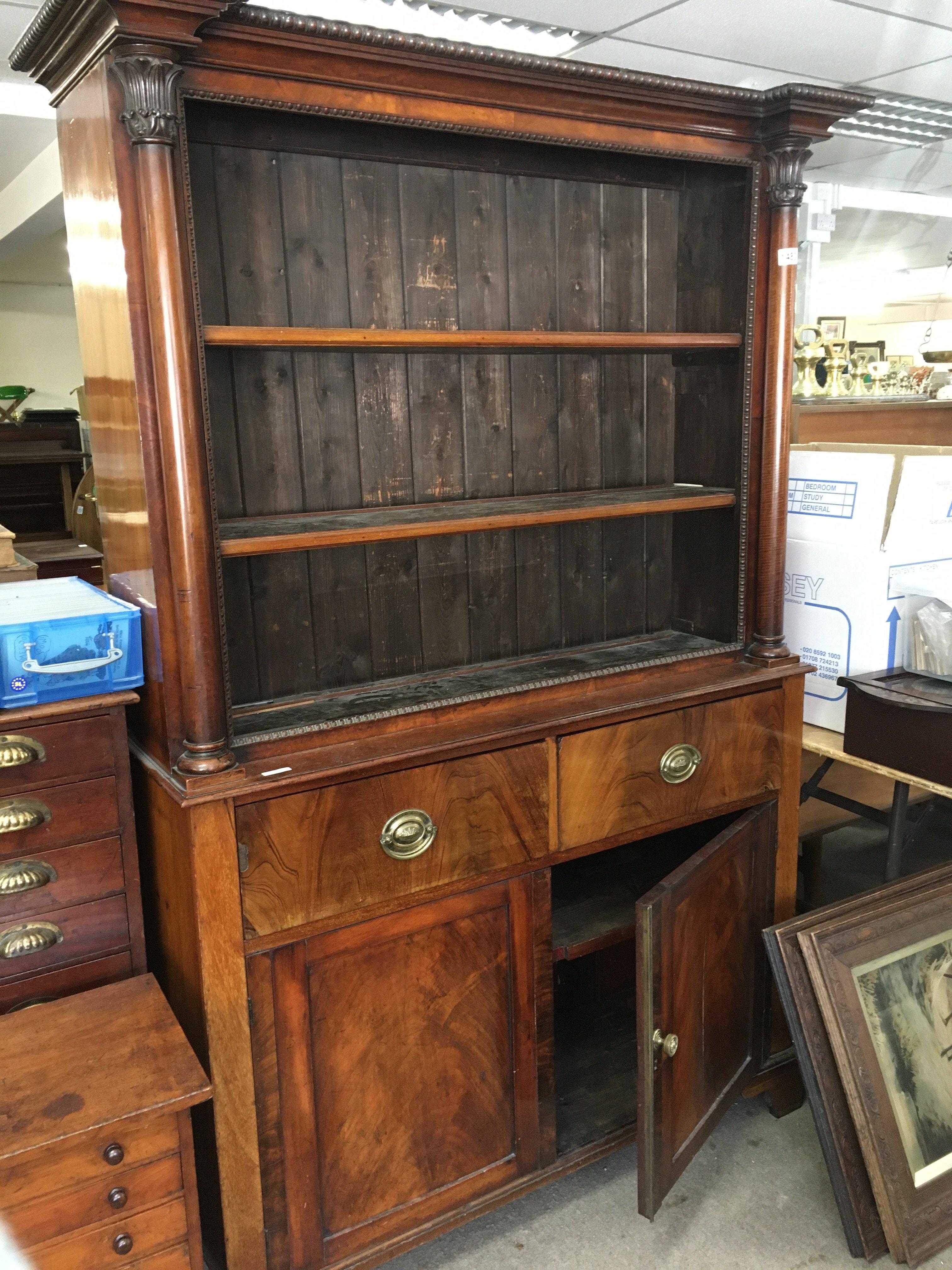 A Victorian open bookcase above two drawers and cupboards under. On bracket feet