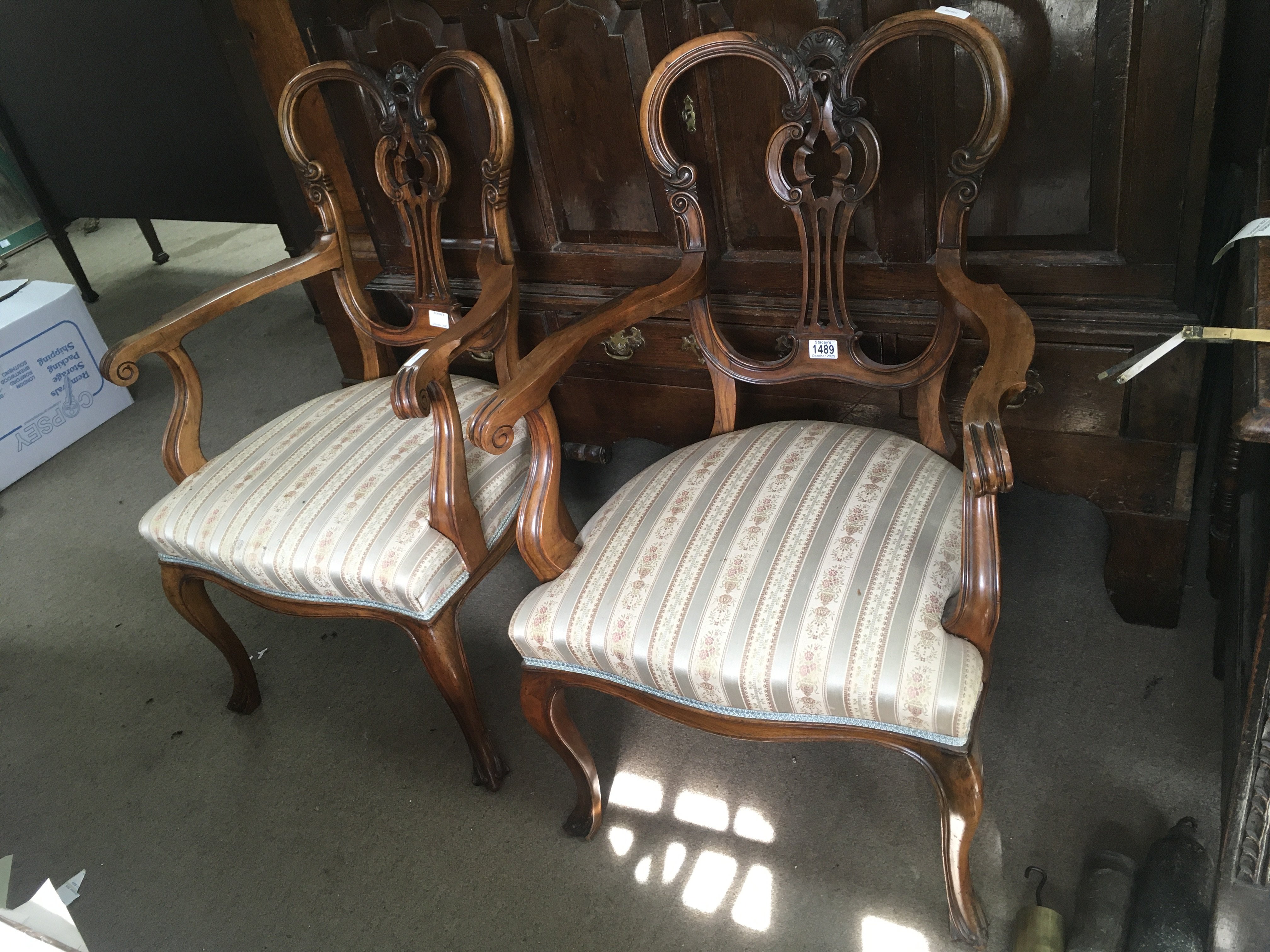 A pair of Edwardian mahogany open arm chairs on cabriole legs