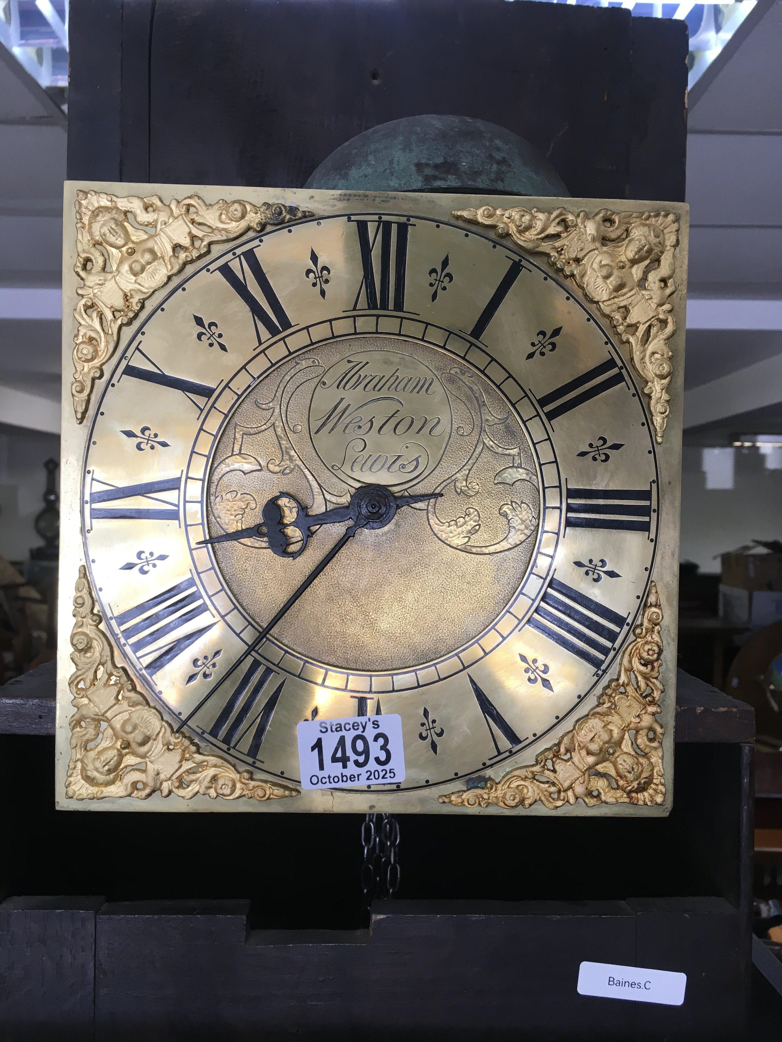 An oak carved 30 hour, brass dial long cased clock. The dial having Roman numerals and 20cm across