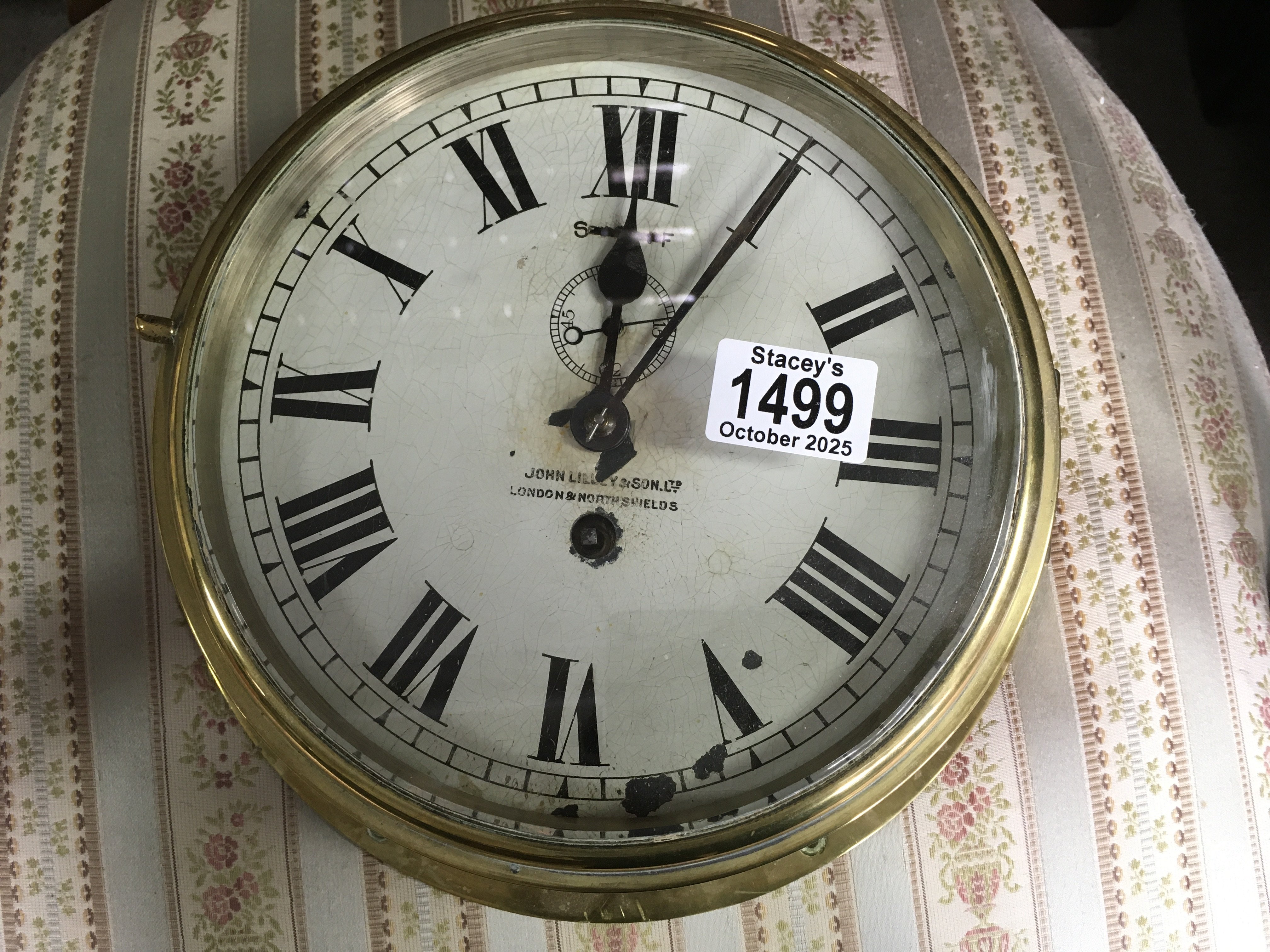 A brass bound ships clock, the dial having Roman numerals. 26cm across