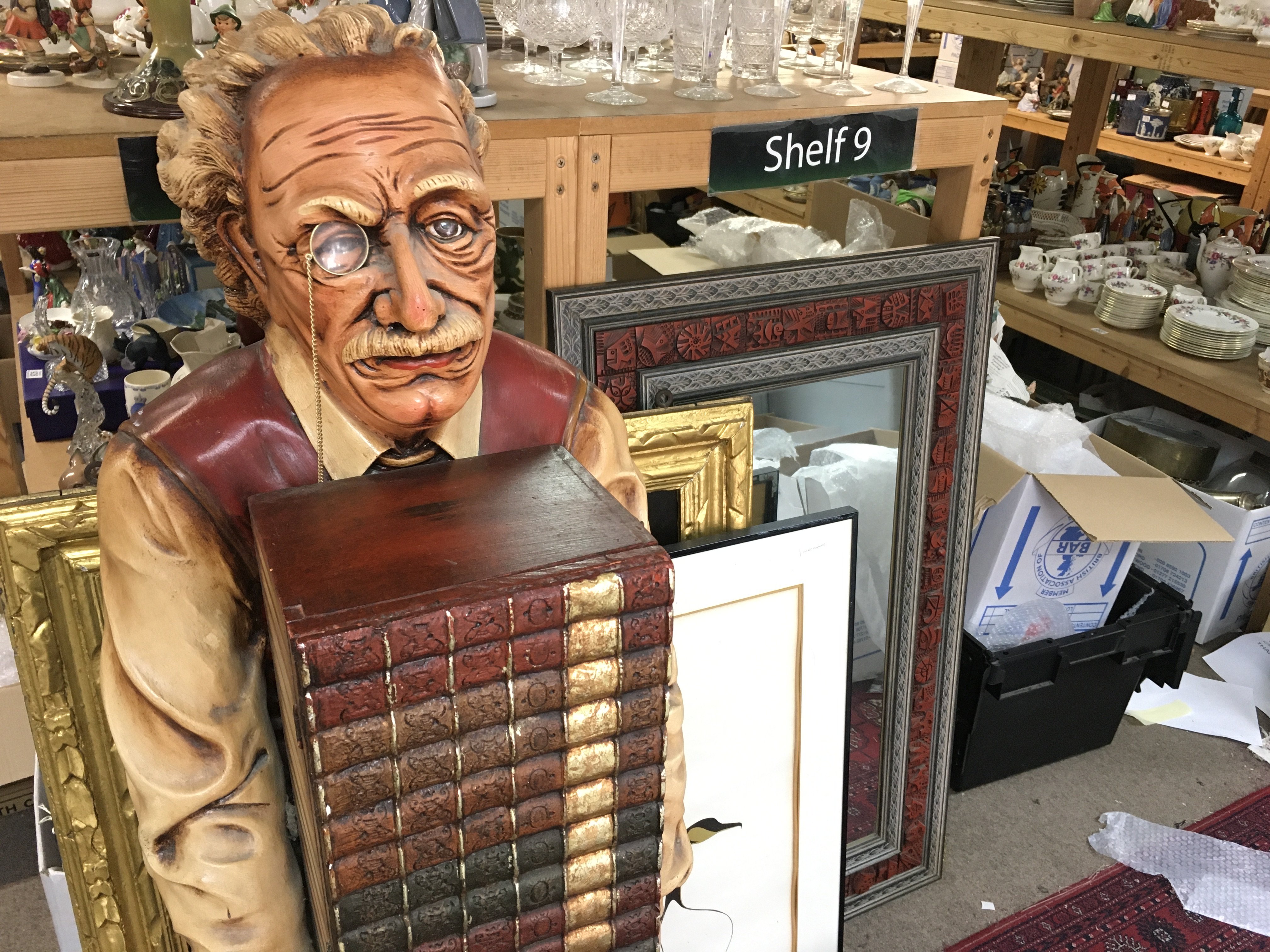Fiberglass sculpture of Albert Einstein holding a stack of books which is actually a wooden cabinet 53 inches tall.