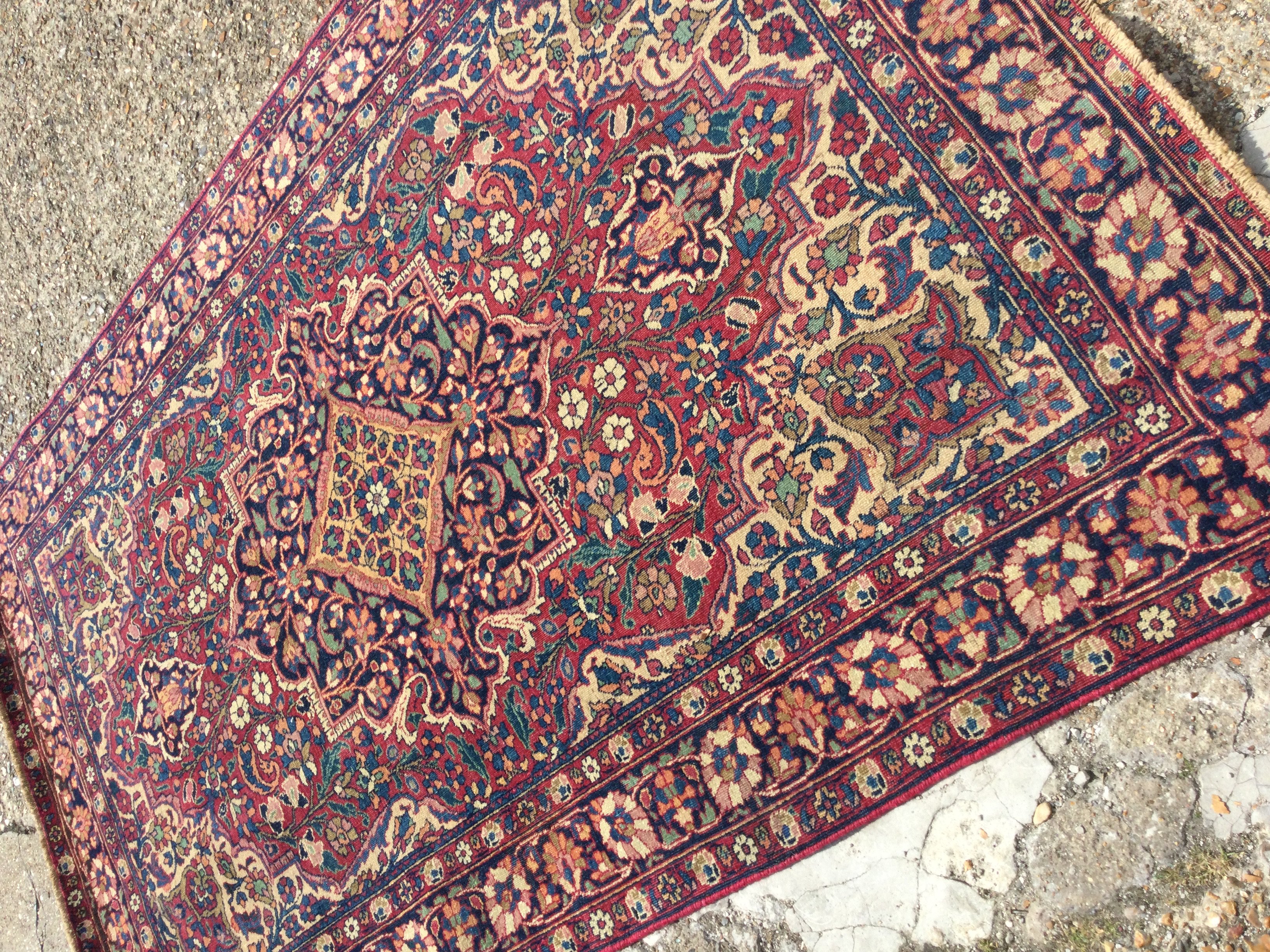 A Kashan rug with central medallion surround y floral motifs. 204 x 130 cm