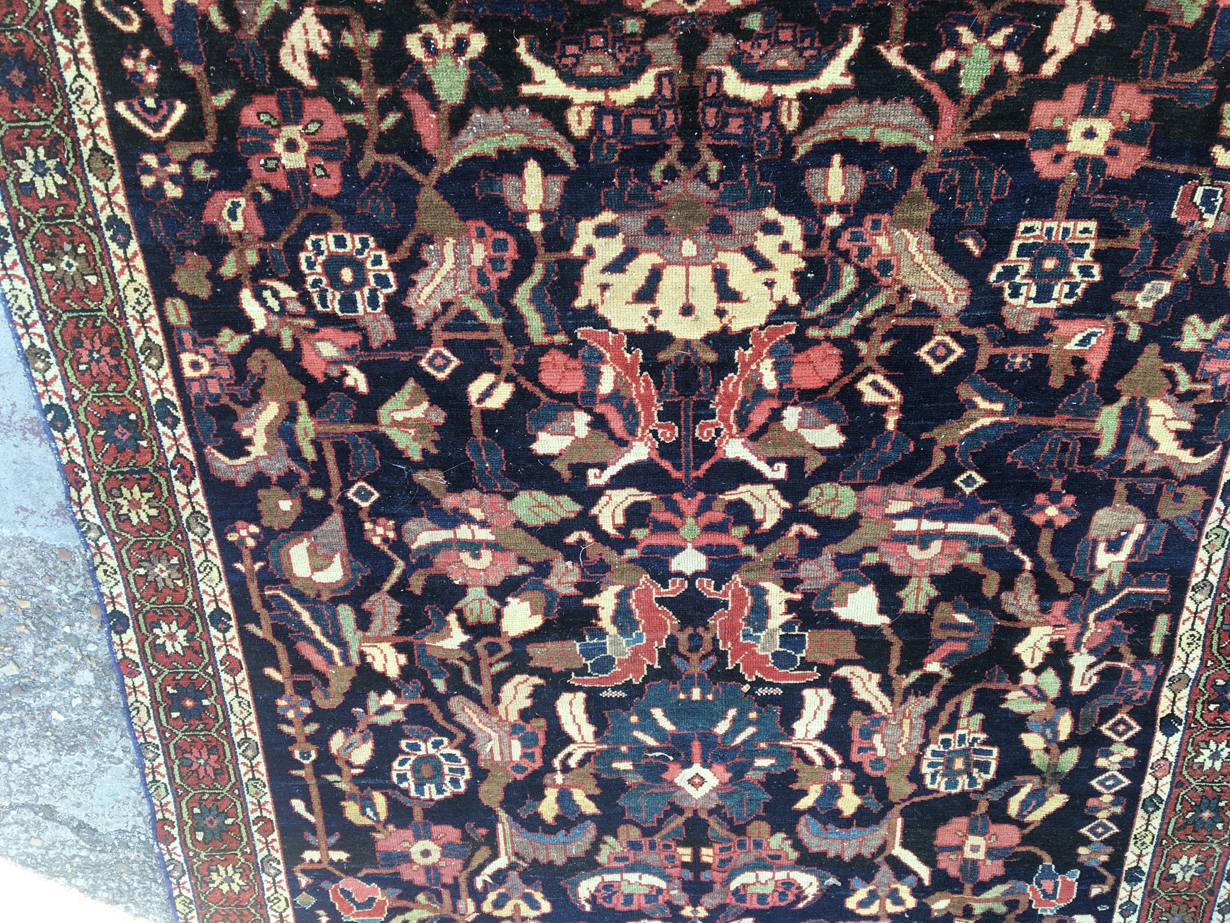A Persian rug with floral central field and a geometric boarder . 210cm x 138 cm .