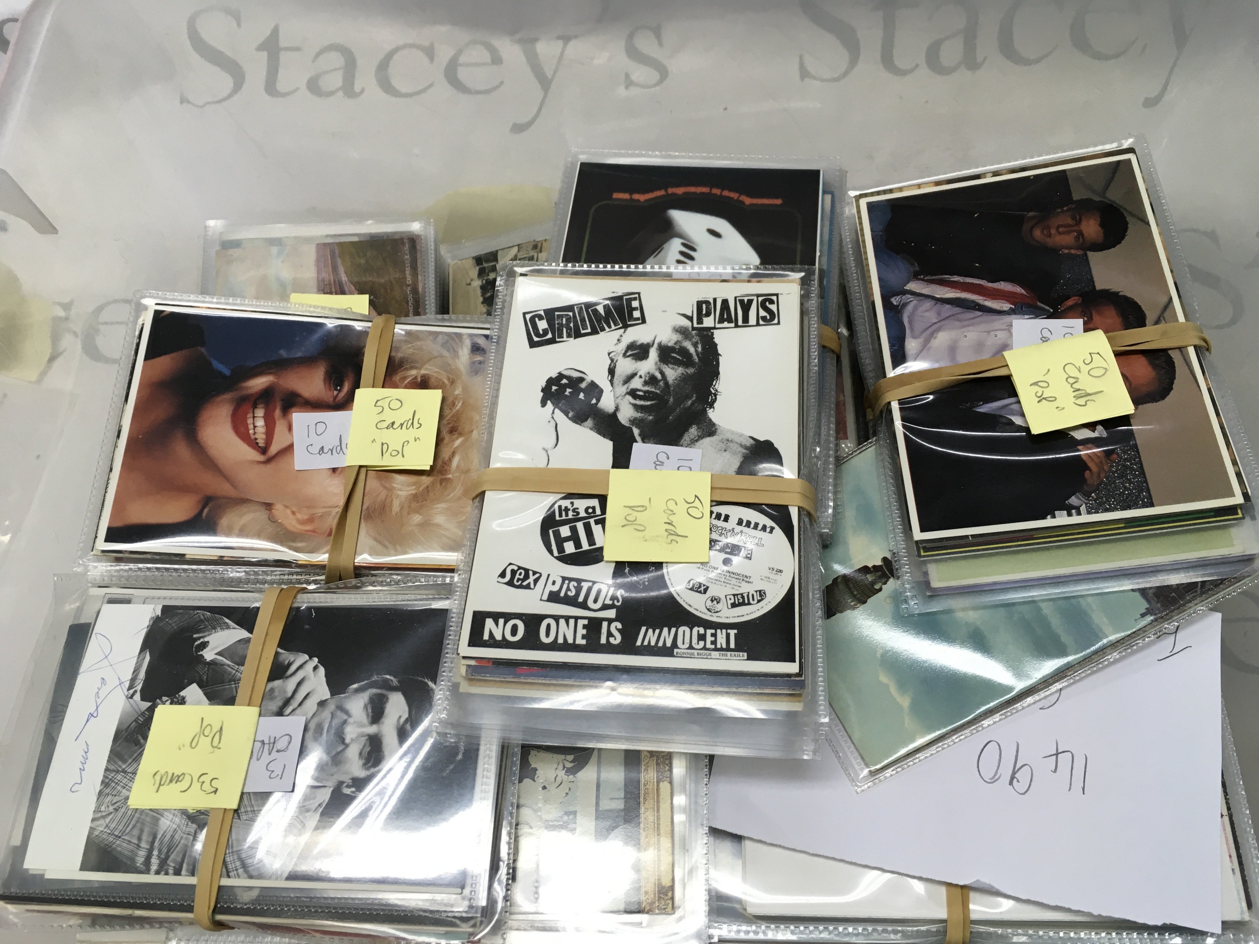 A box containing various vintage postcards including music, trains , locations etc