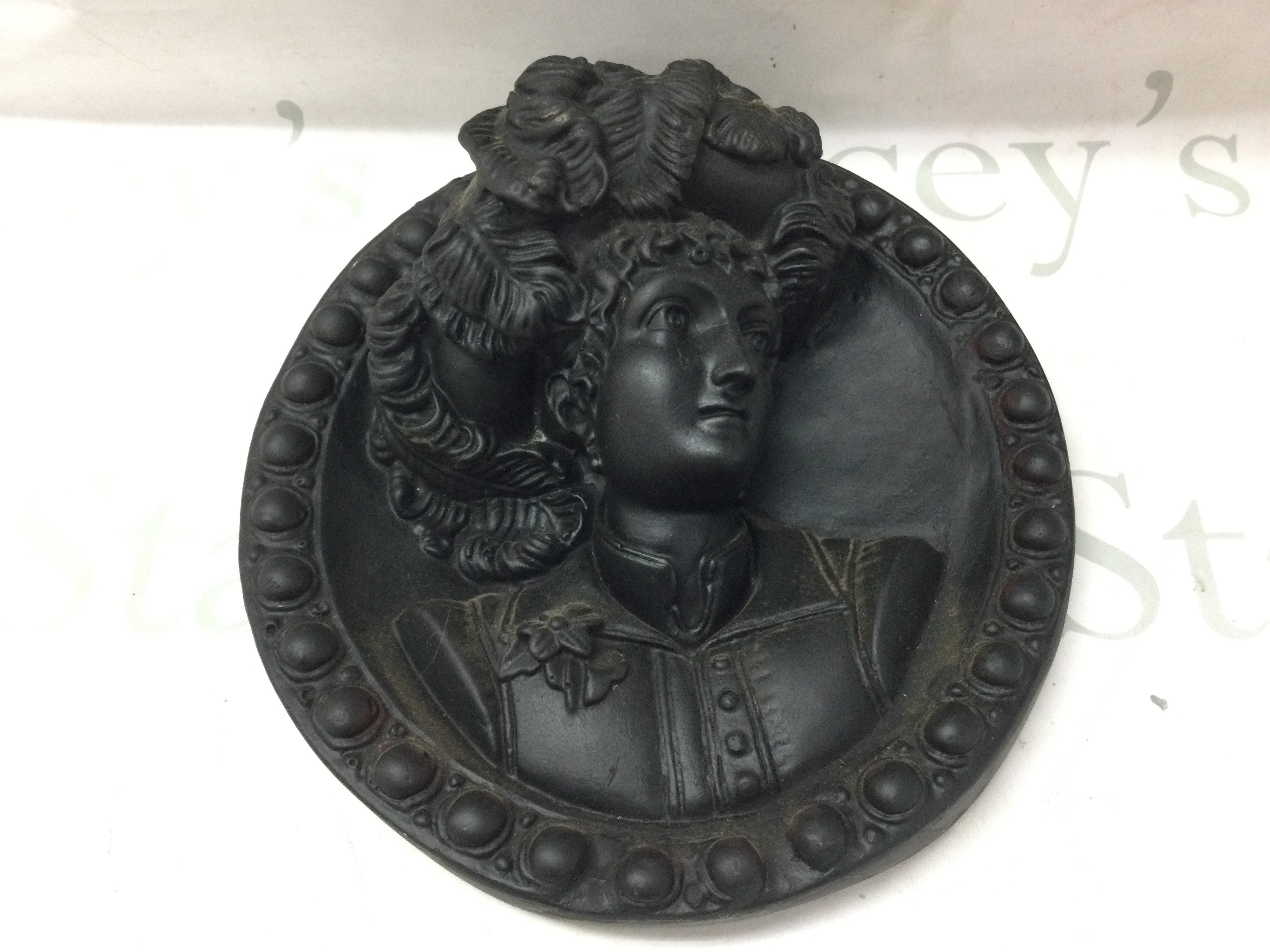 A Victorian plasterwork black plaque , 27cm wide. This lot cannot be posted
