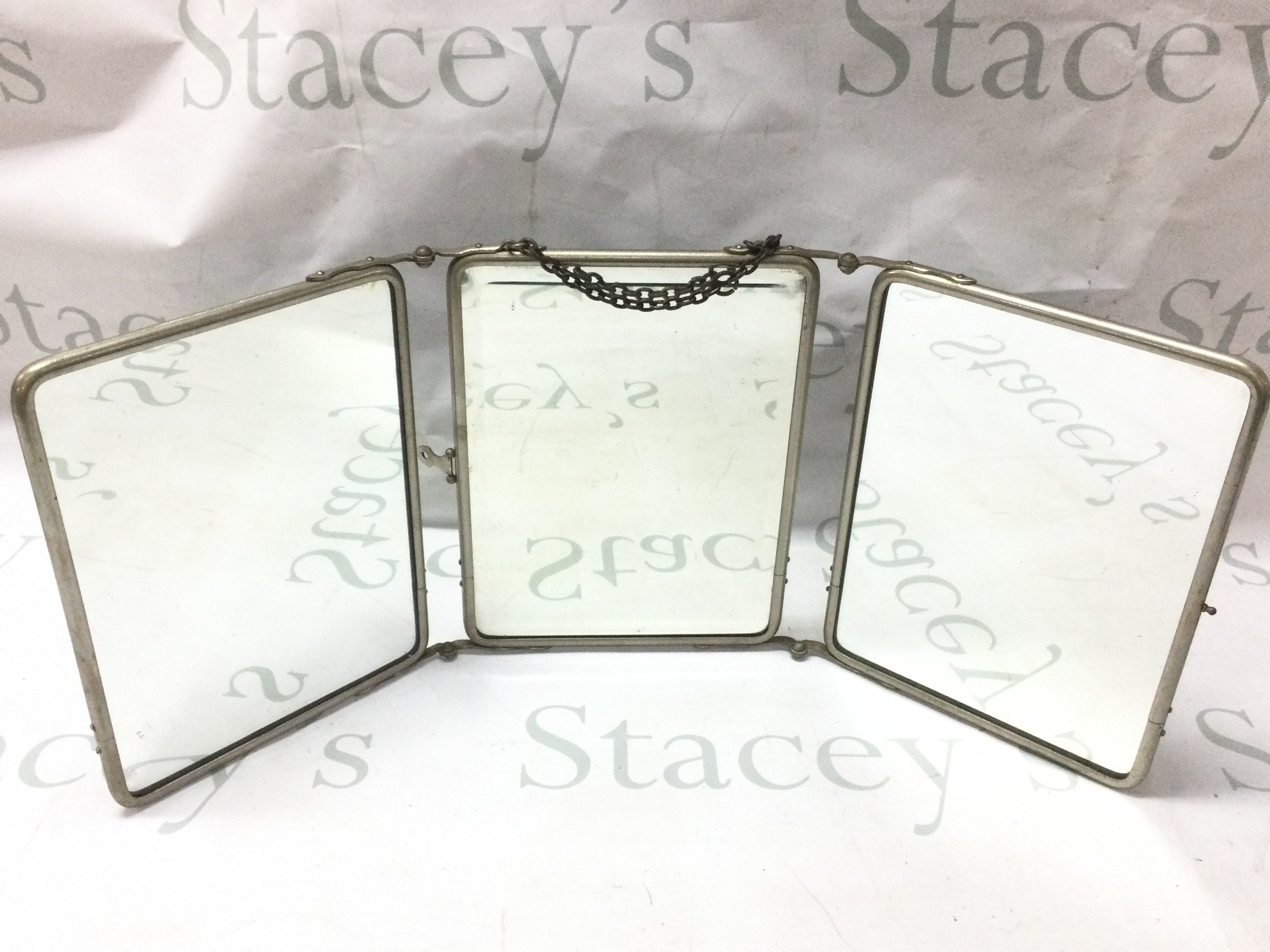 A good vintage three mirror carrying mirror with chain, handle and embossed flower covers. Each panel 18x24cm This lot cannot be posted