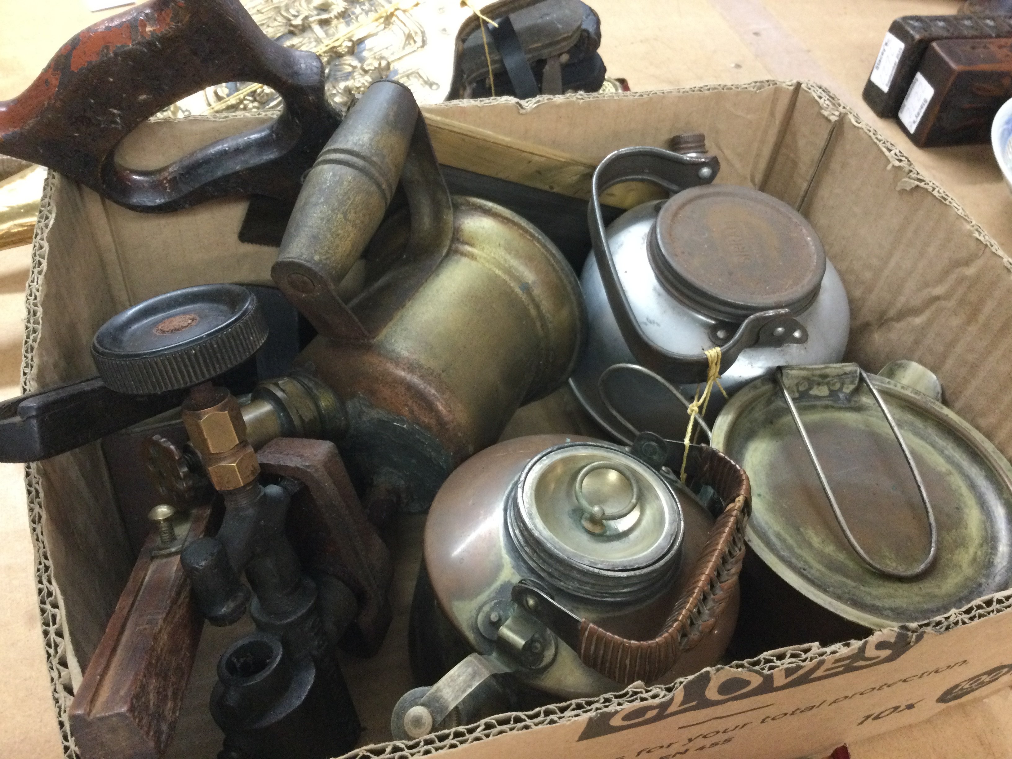 A box containing vintage tools and cans