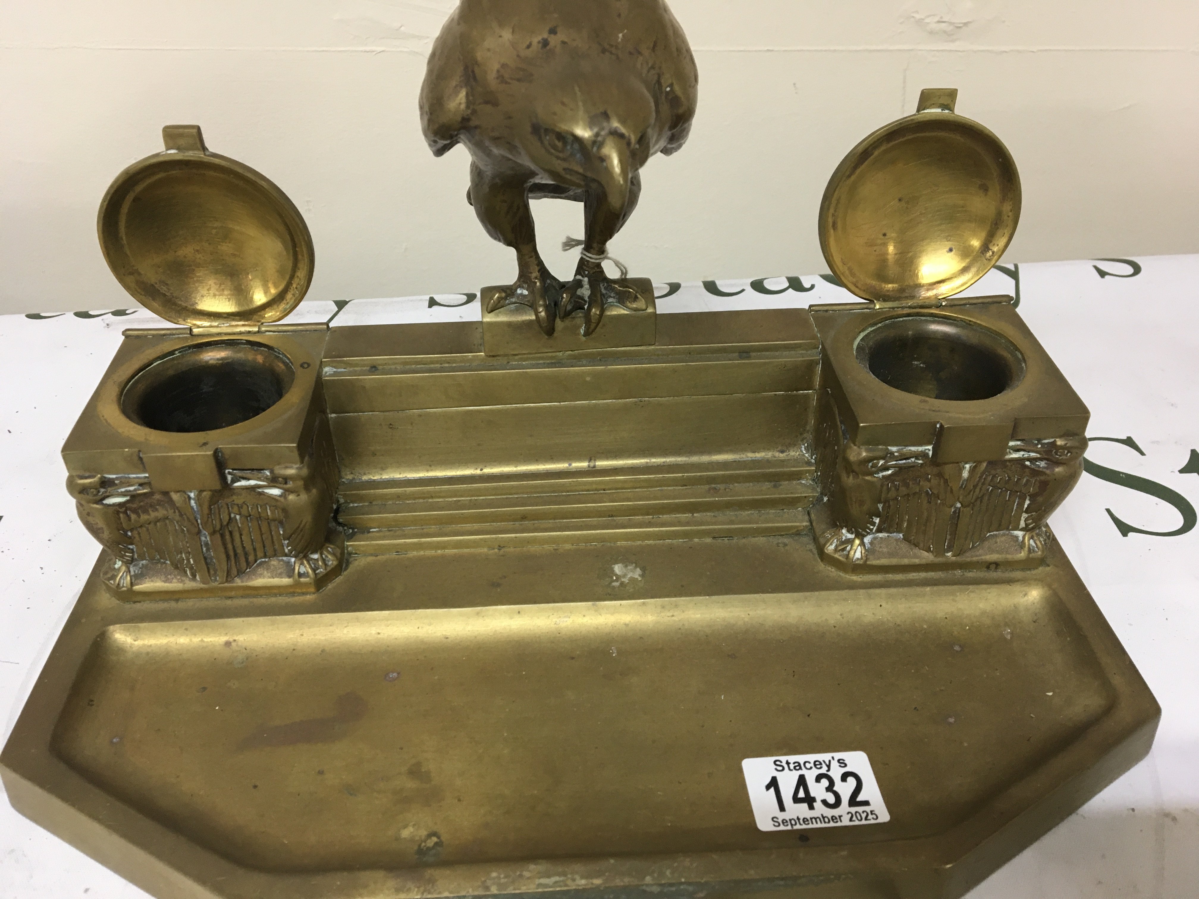 An Art Deco desk top pen tray and inkwell The ink well surmounted with a solid cast Eagle flanked by ink wells. Width 35cm