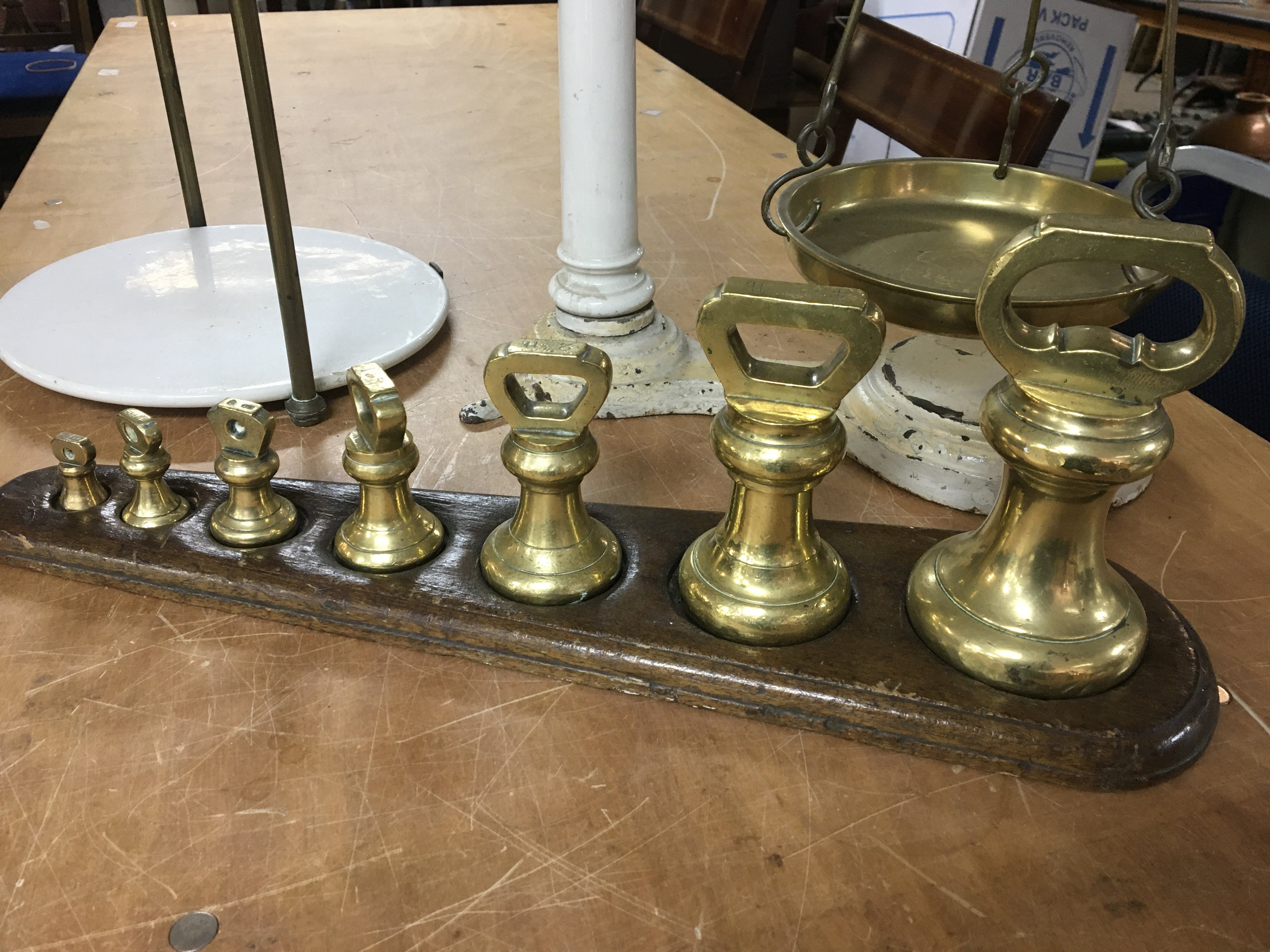 A set of antique enamel beam balance scales with brass fittings and a set of graduating brass bell weights.- NO RESERVE