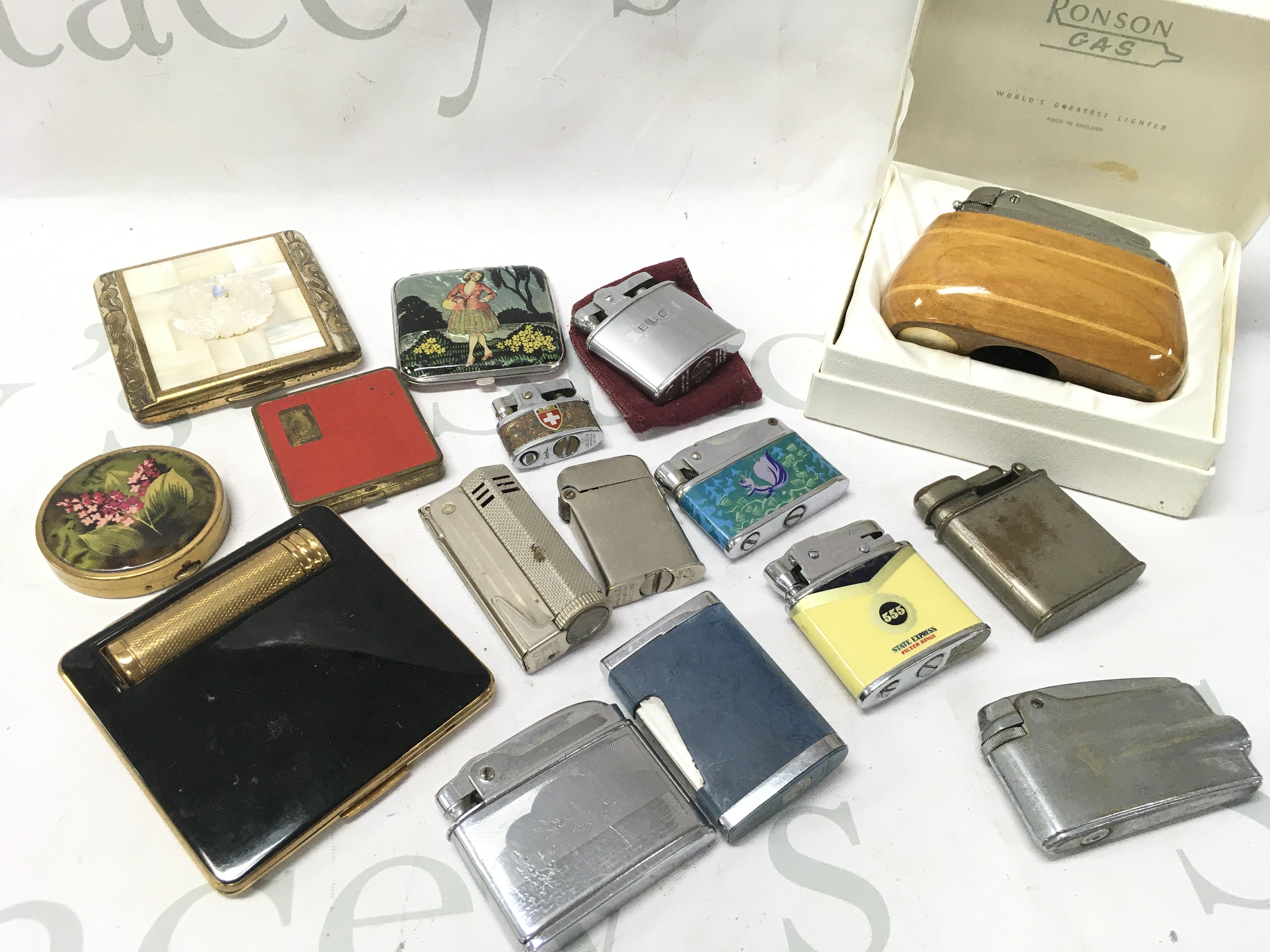 A collection of lighters and compact mirrors . No reserve. Postage category B