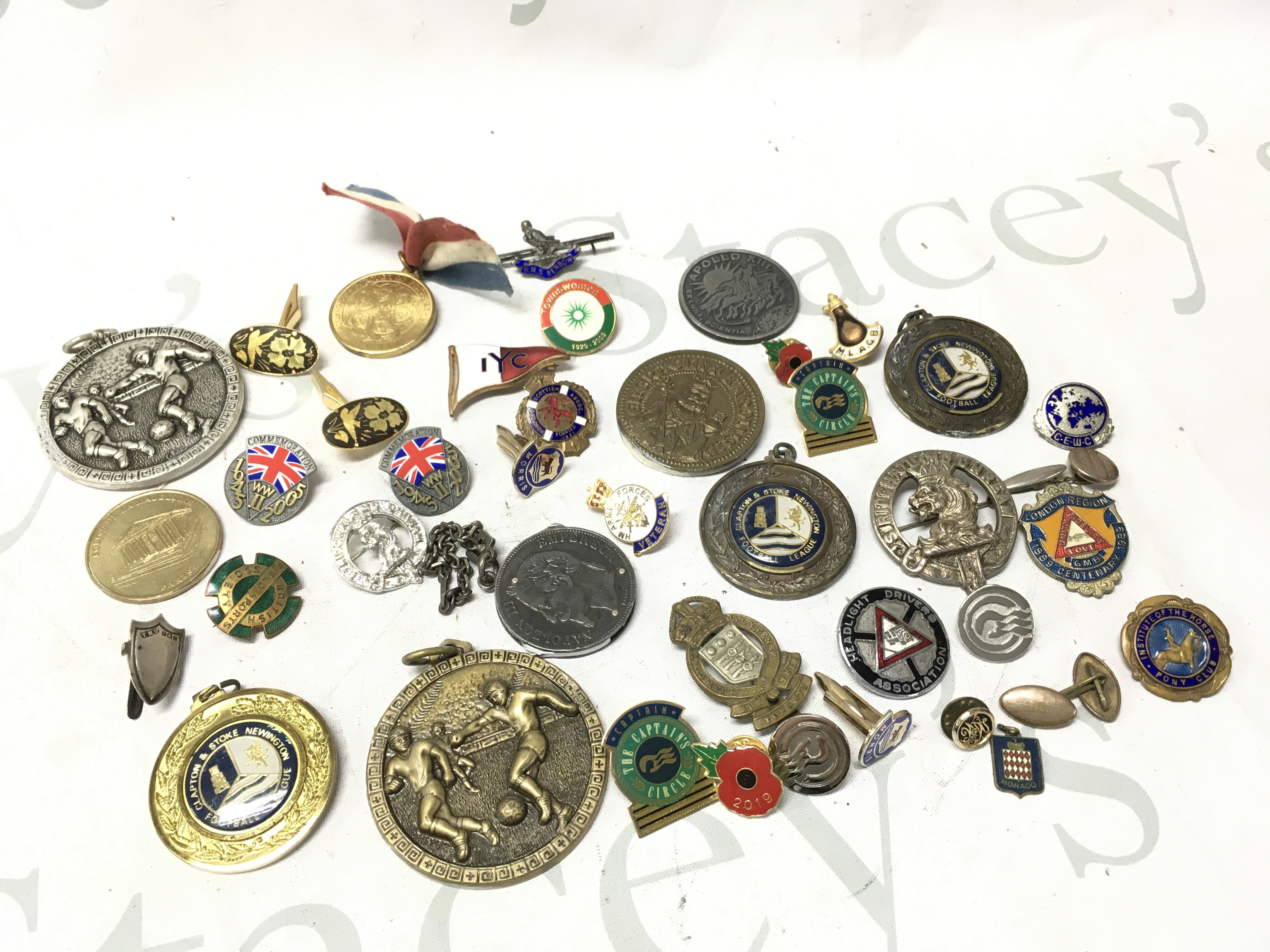 A collection of badges including commemorative pins, poppy pins, cap badges . Postage category a