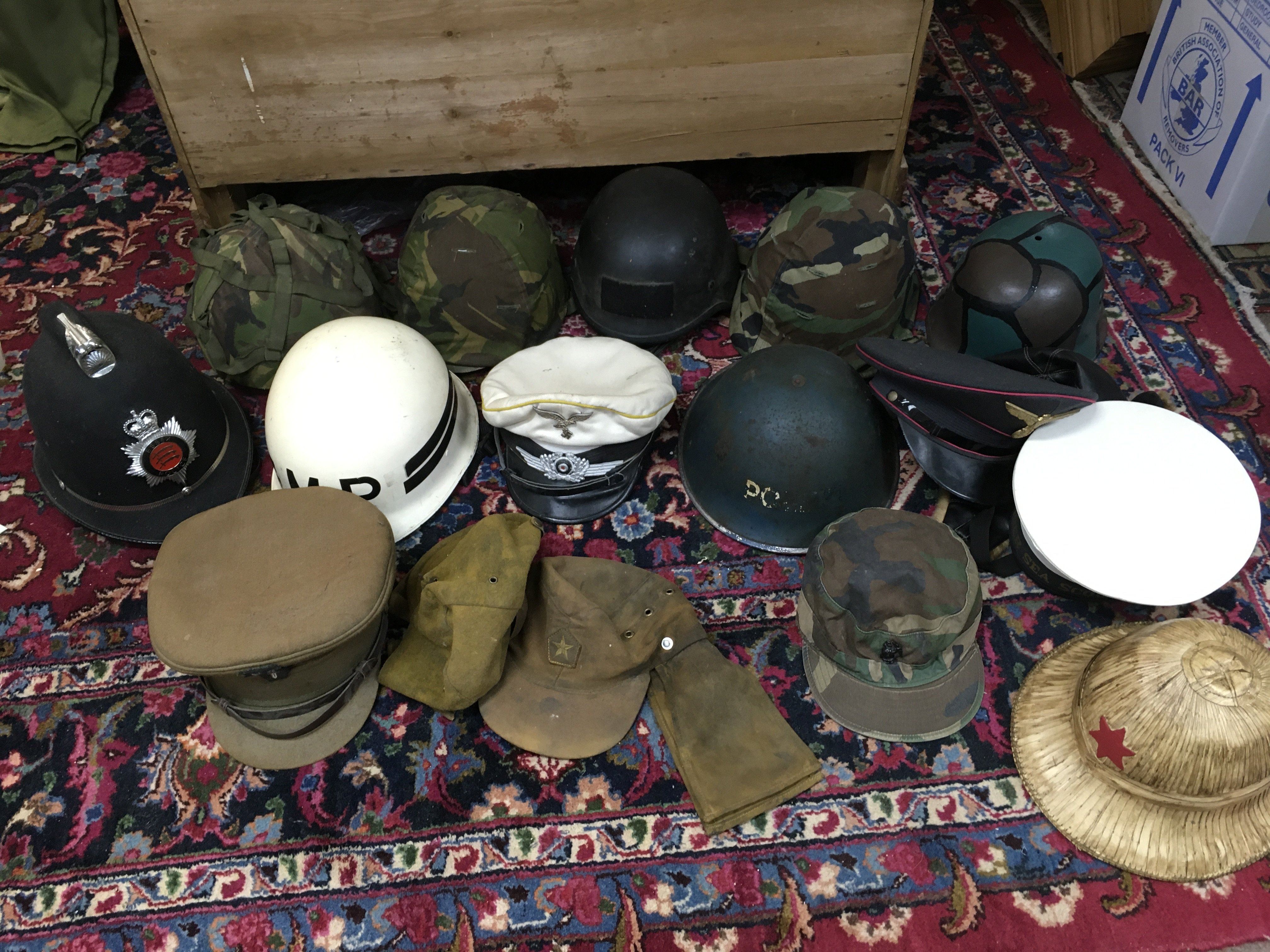 A collection of retrospective military helmets and hats including a Luftwaffe white topped cap, soviet Afghanistan hat