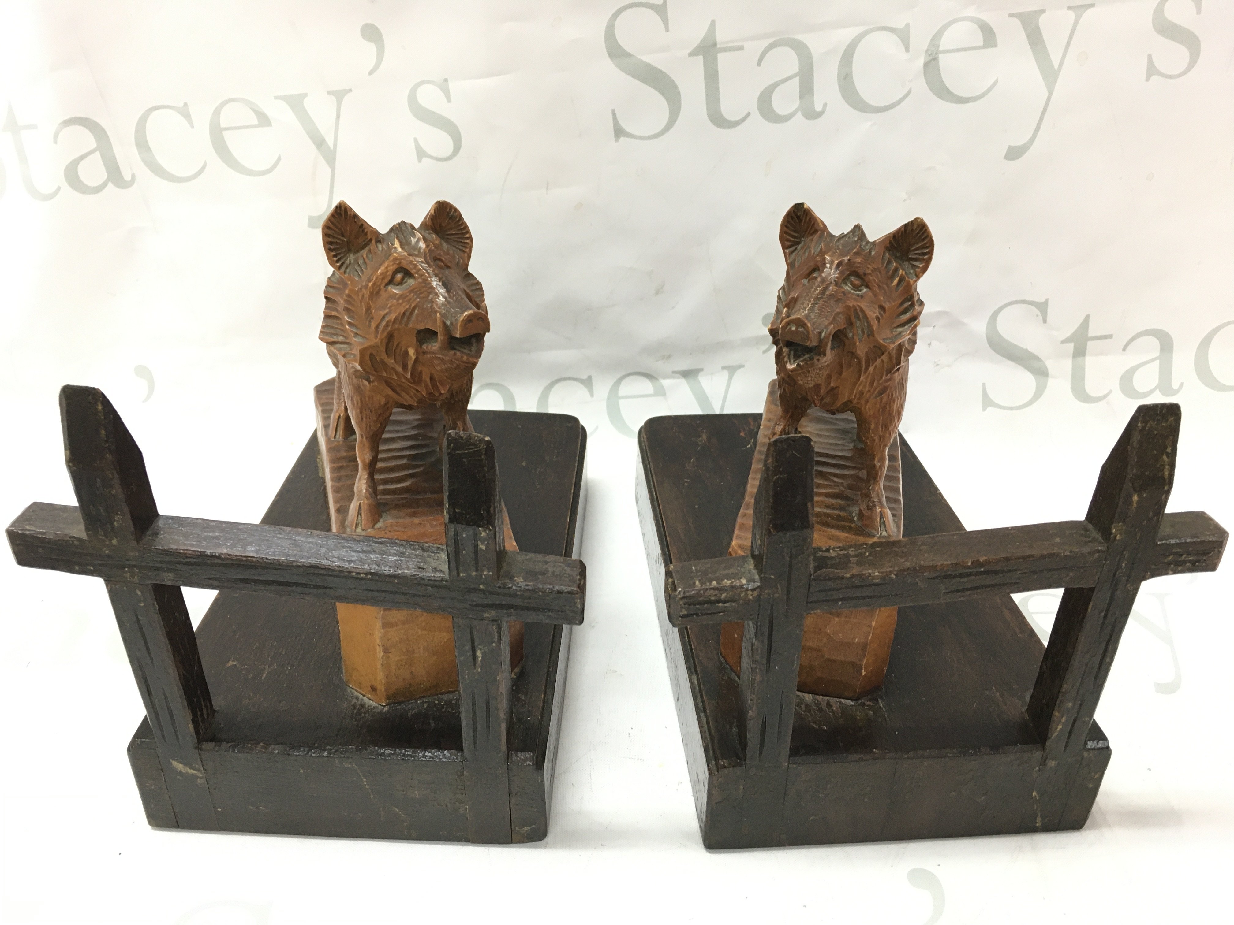 A pair of black forest carved book ends in the form of wild boars ,19.5cm tall 24cm wide . Postage cat C
