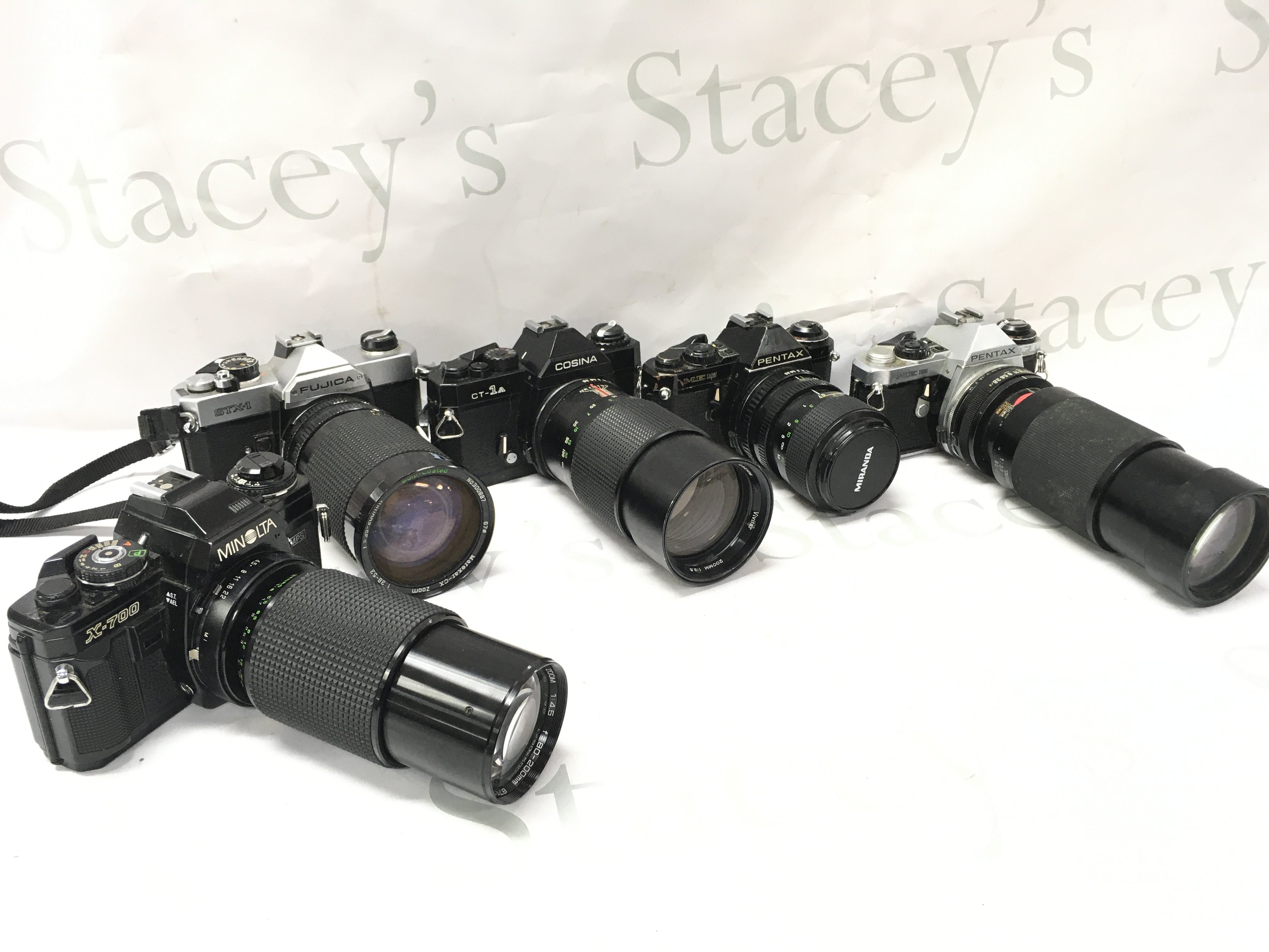 Five vintage SLR cameras including Pentax ME super with Tamron 210mm lens, Codina CT-1A with vivitar 200m lens, Fujica STX-1 , Minolta X-700 with Makinon 200mm lens. This lot cannot be posted