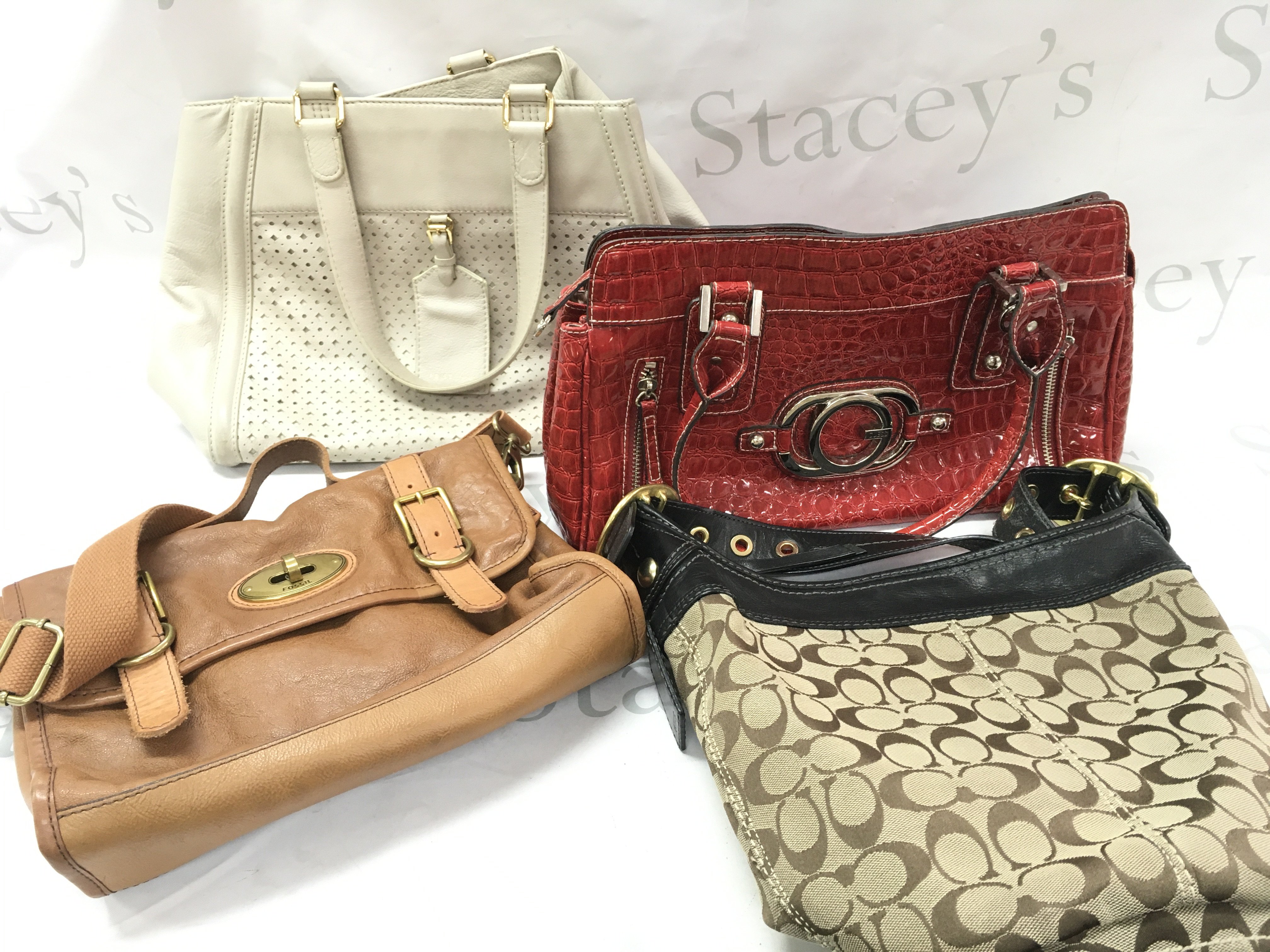 Four designer hand bags including Coach, Fossil, Guess, Reiss London. Postage category C