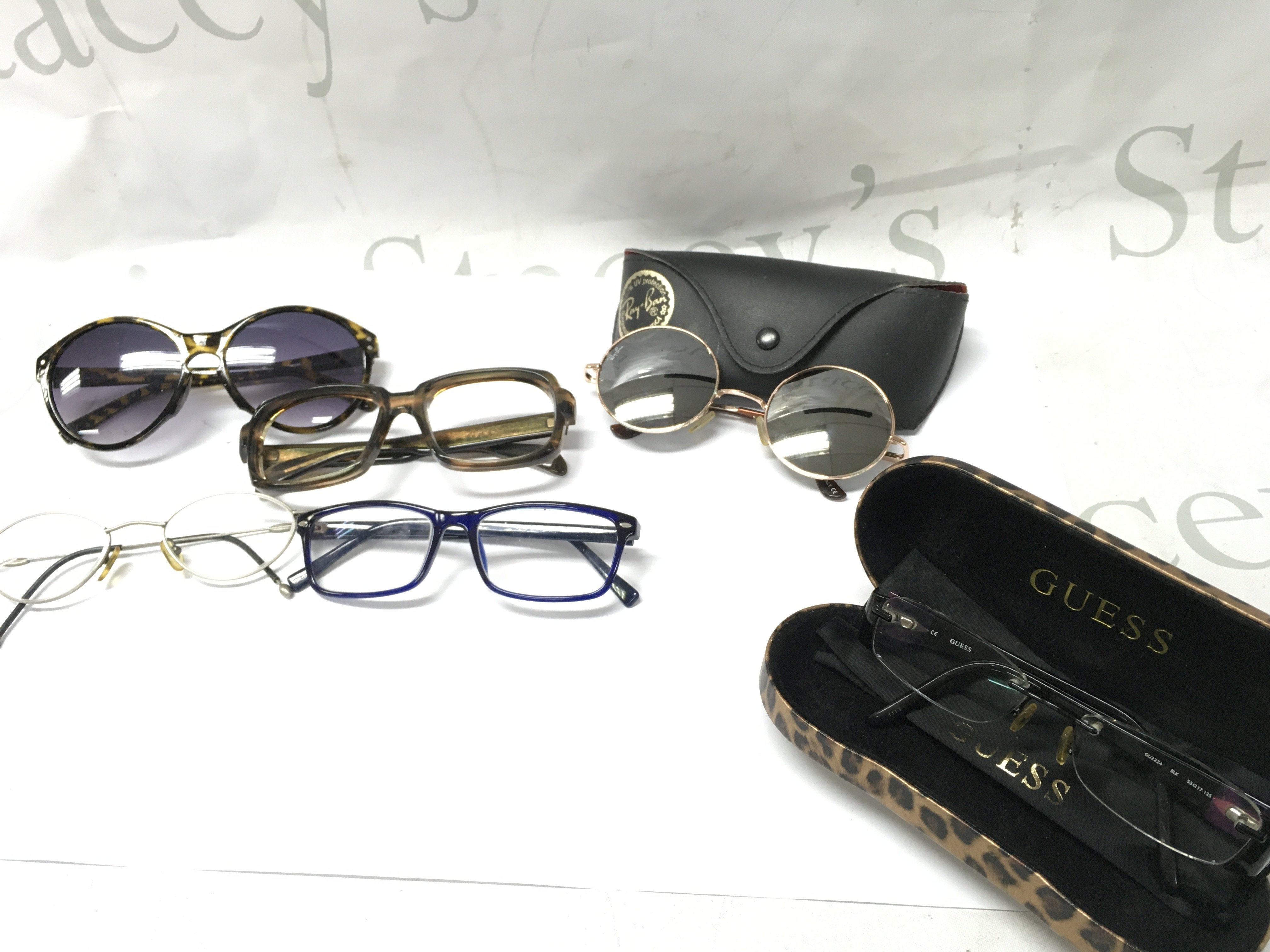 A Collection of sunglasses including Ray Ban, Guess and other named frames . Postage category B