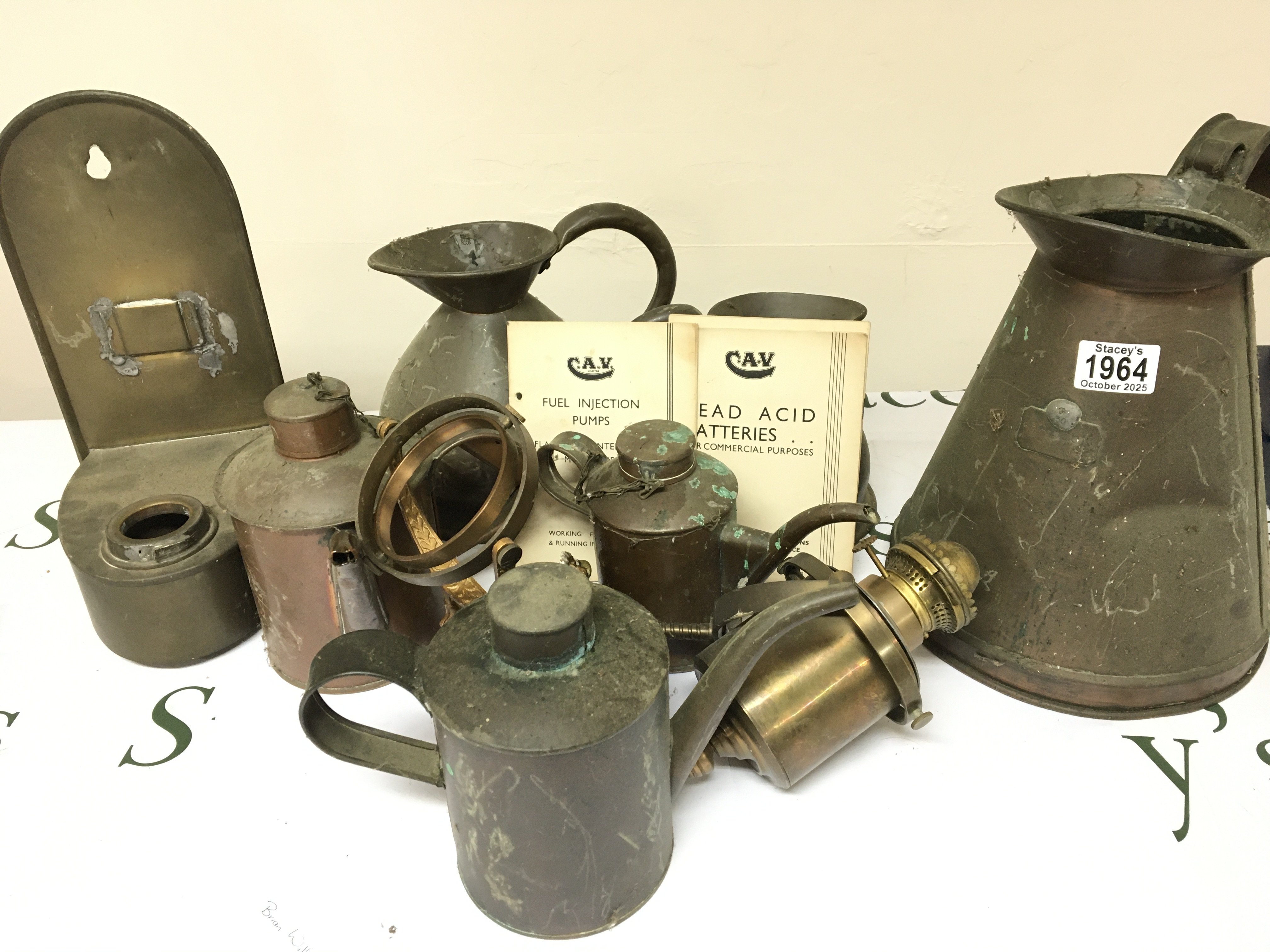 A Collection of Antique copper and brass including measuring jugs oil lamp on a gimbal small cans Vintage CAV car service manuals and a box of glass oil lamp shades.