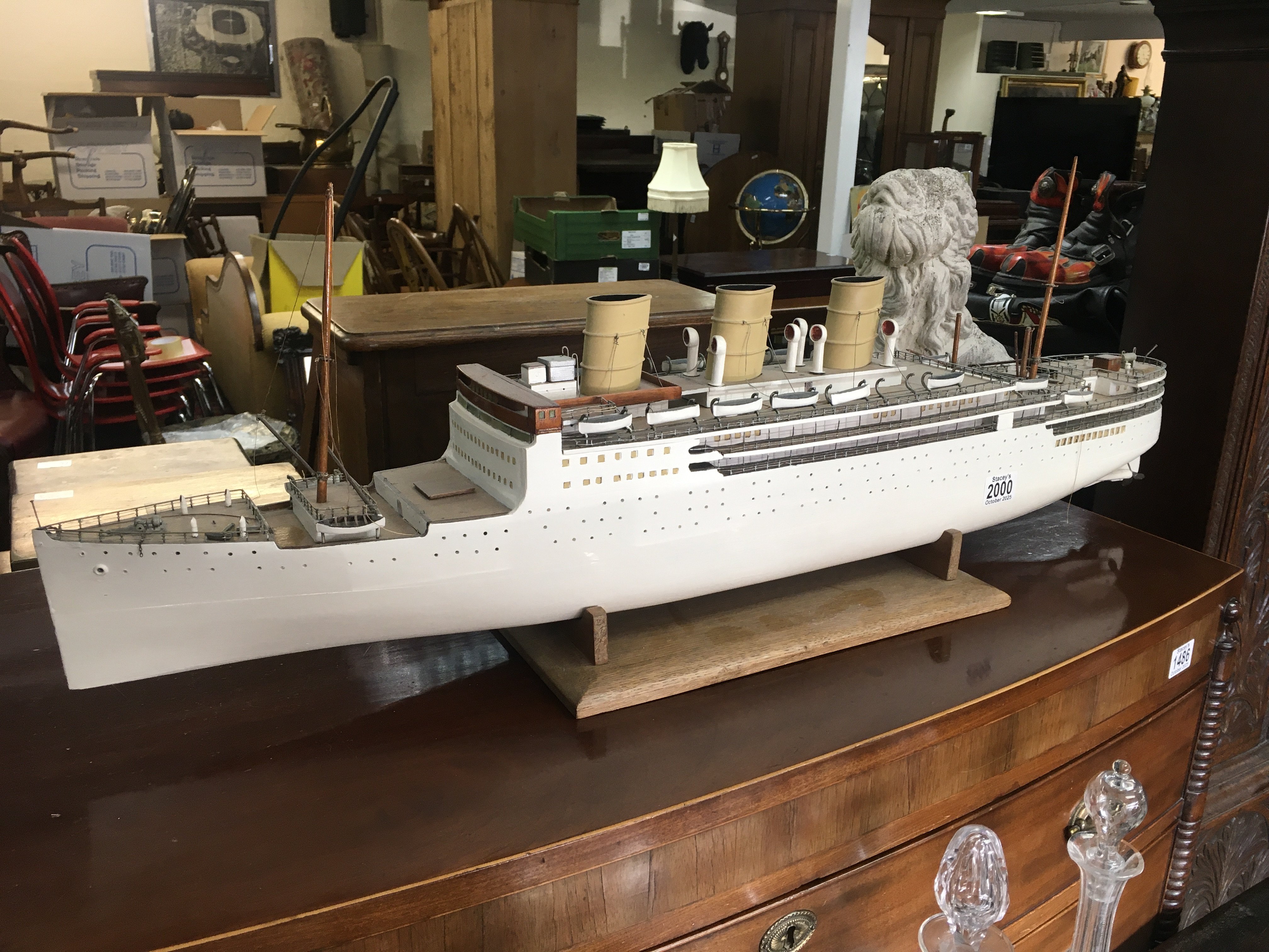 A model of a three funnel steam ship on a wooden base support