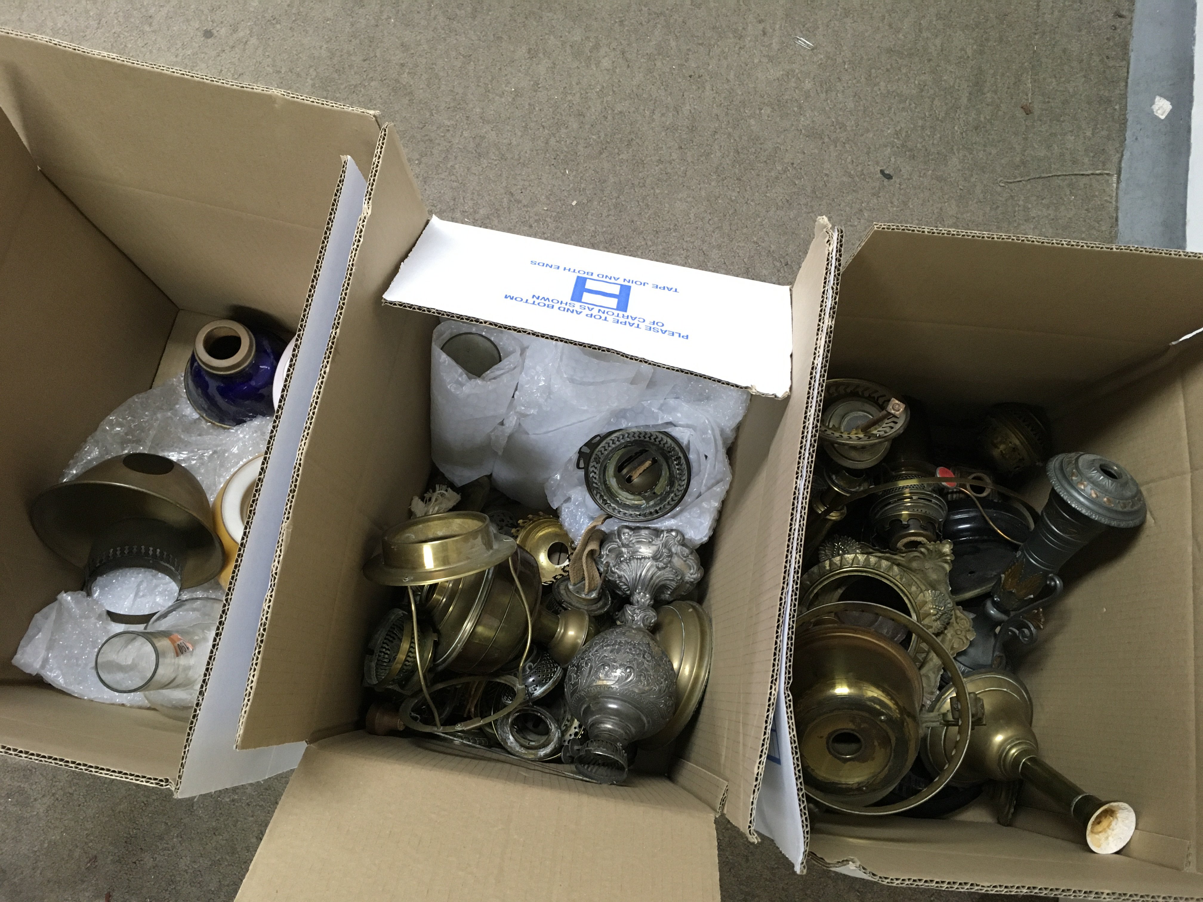 Three boxes containing Victorian oil lamp parts, shades and chimneys